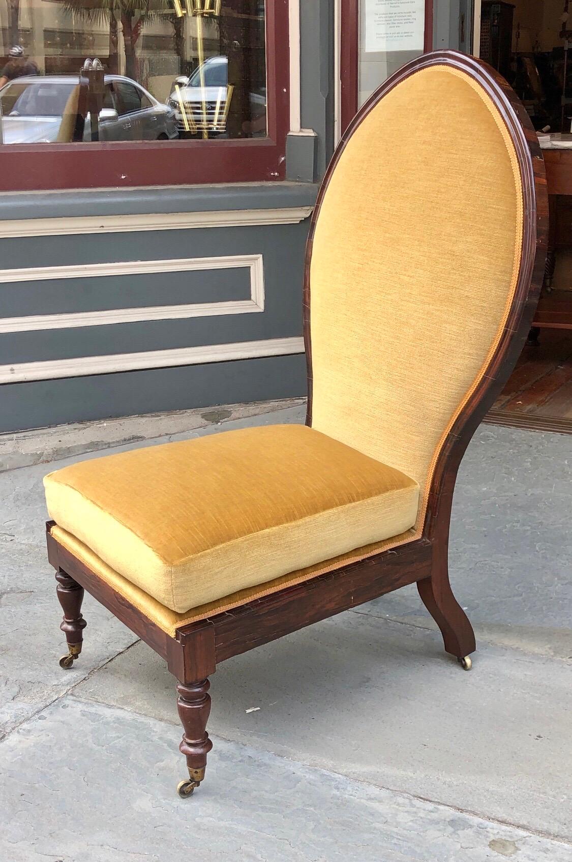 This Exotic Anglo-Indian Regency Chair was made in India in the Raj Form. This elegant Rajah Chair has a pronounced Lotus Stylized back in the Aureole form that is used in Mughal Design. The Aureole Back is framed in Rosewood that has a thumbnailed