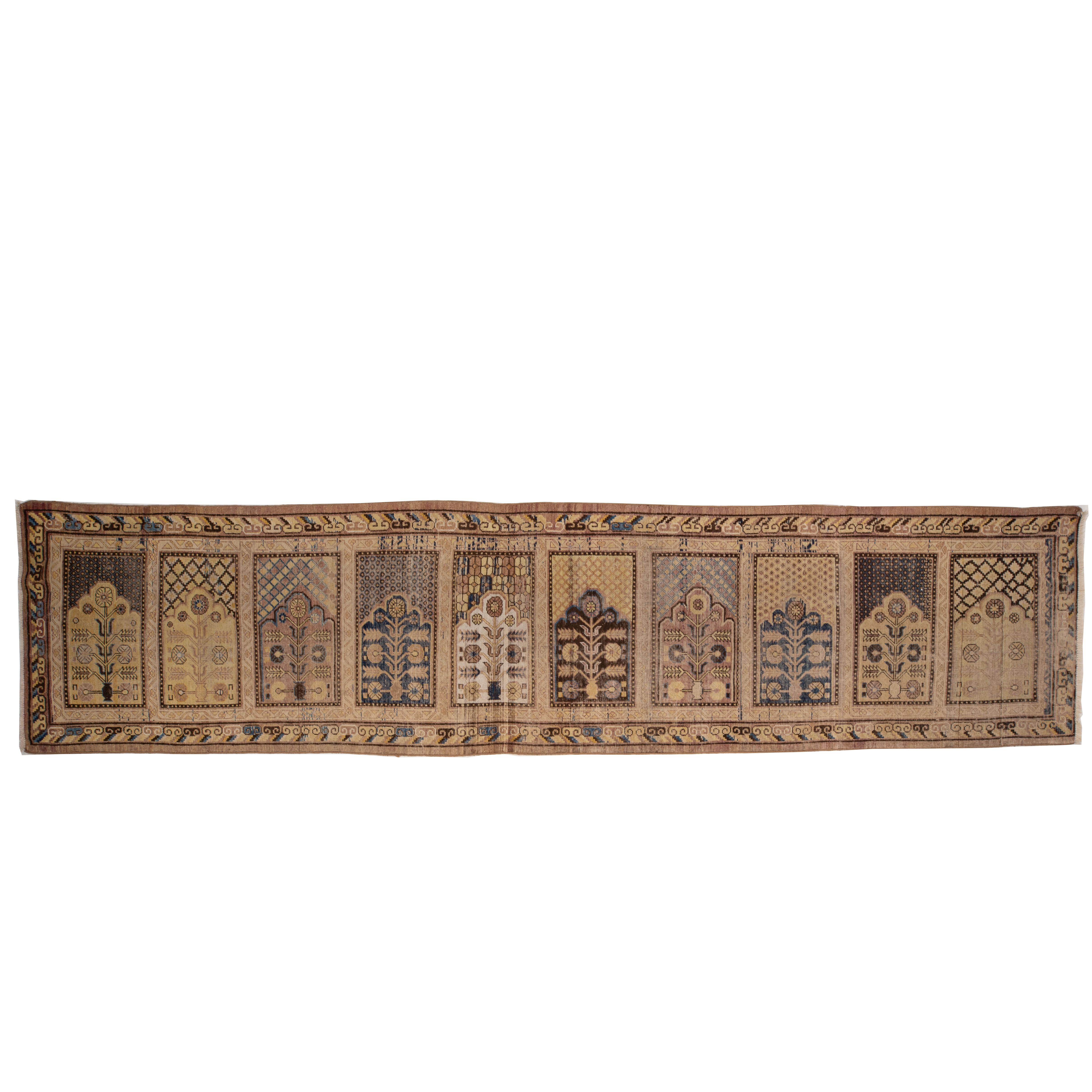 A slightly worn out Khotan rug with soft coloyurs , from the turn of 20th C.
