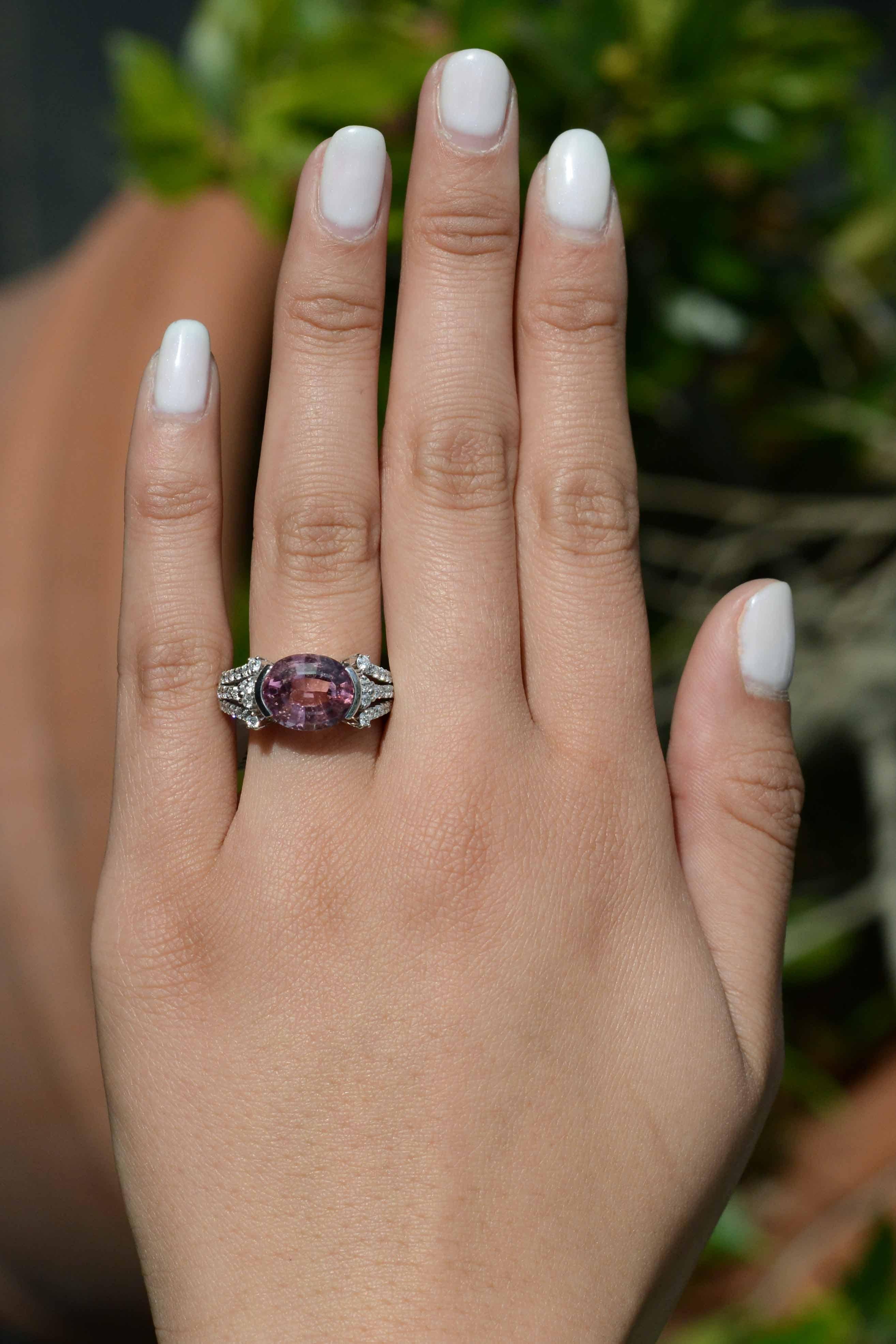 Dieser Ring im Stil zwischen Ost und West ist mit einem atemberaubenden 7-karätigen rosa Turmalin und 38 Diamanten im Rundschliff besetzt. Der Turmalin hat eine rosafarbene Farbe mit orangefarbenen Reflexen. Die Reihen der eingefassten Diamanten