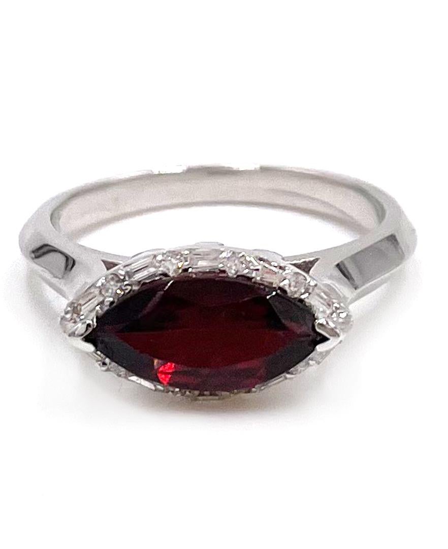 14K white gold east west ring with baguette and round diamonds 0.20 carat total weight. The center is set with one marquise  shape garnet weighing 1.73 carats.

* Diamonds are H/I color, SI clarity.
* Finger size