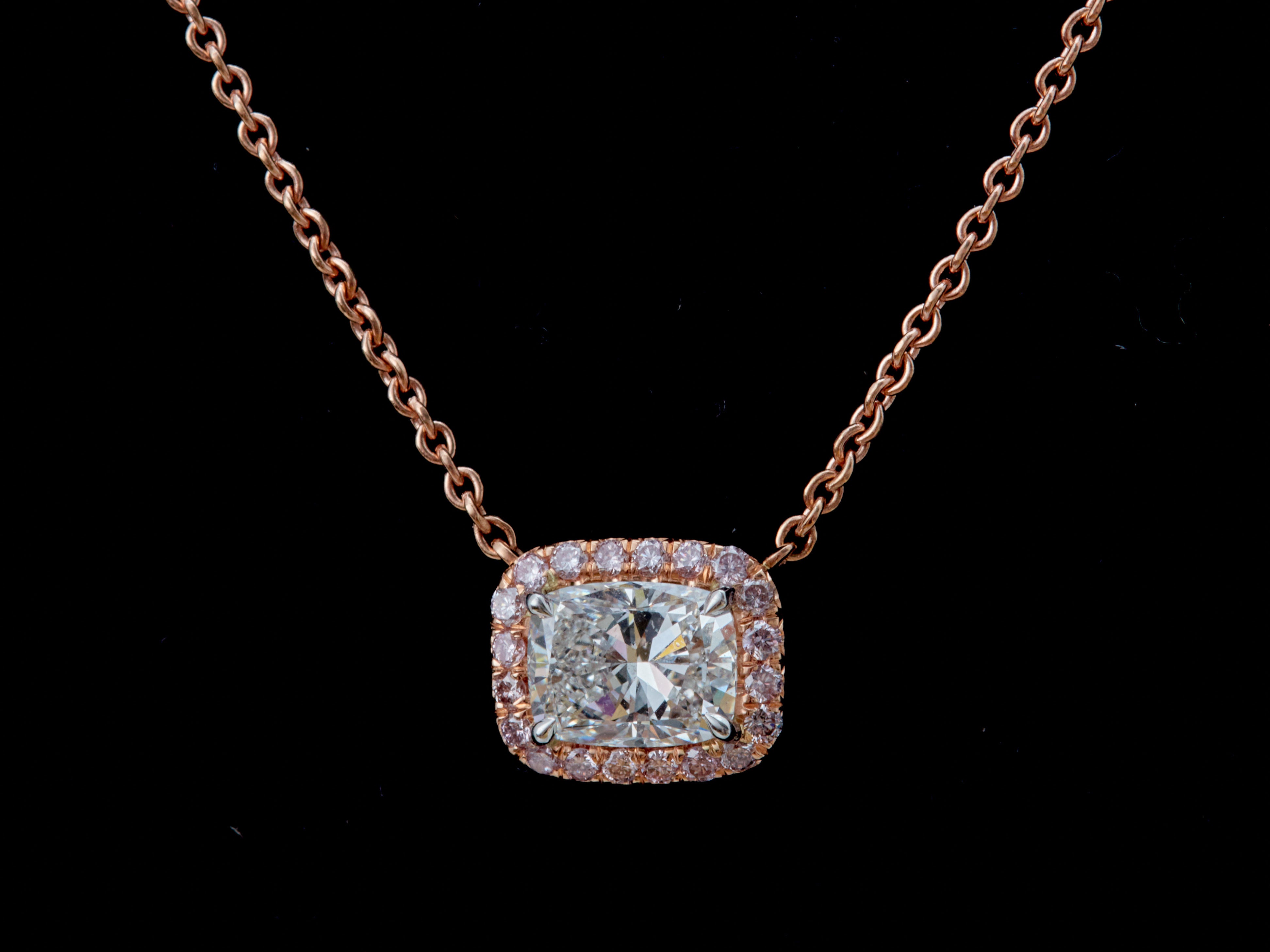 Ce collier est composé d'un magnifique pendentif en forme de halo en diamant de style est-ouest, mettant en valeur un diamant de taille coussin de 1,50 carat certifié par le GIA de couleur G et de pureté VVS2. Le design classique fait ressortir la