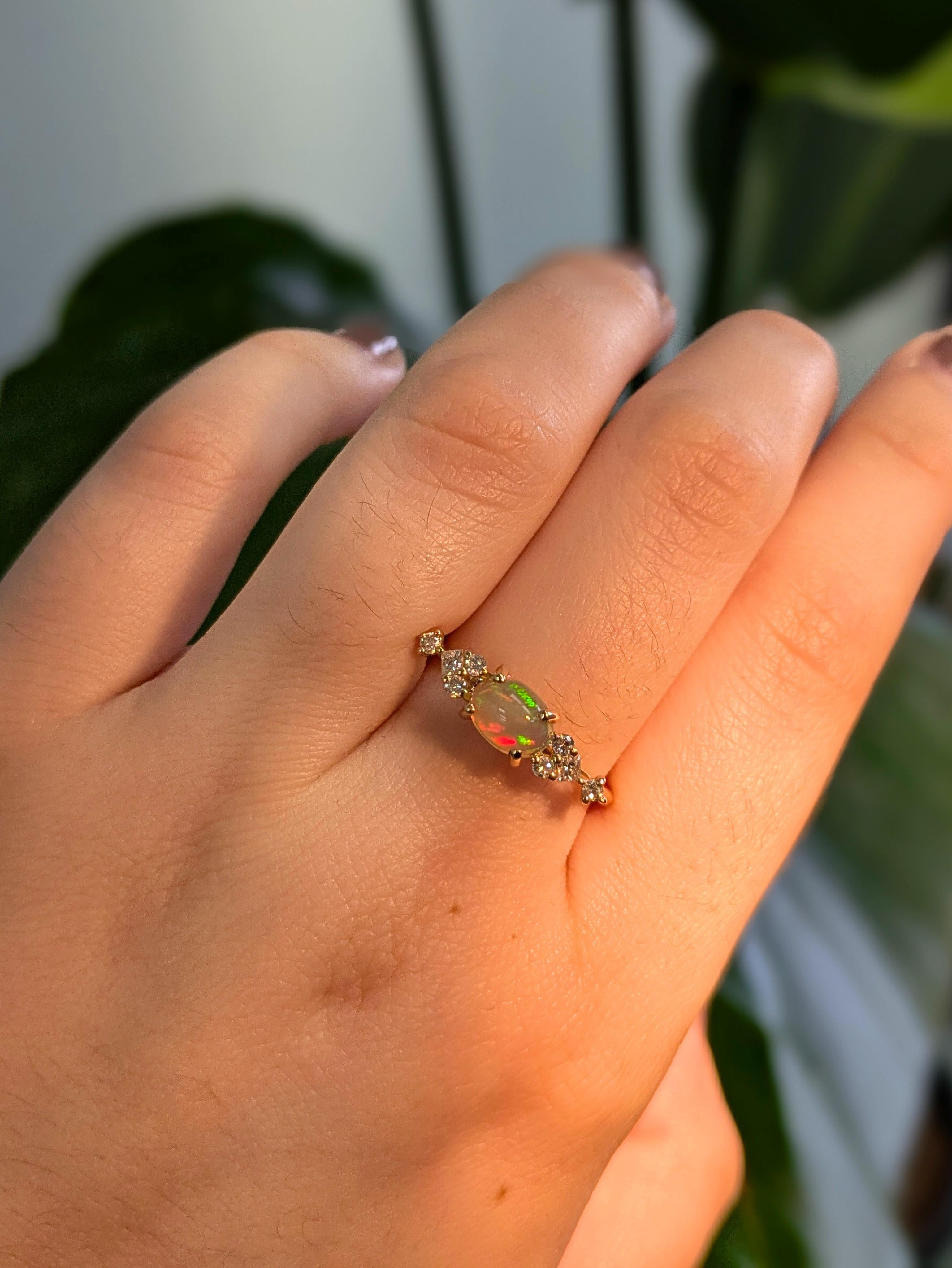 Cette ravissante opale présente toutes les couleurs de l'arc-en-ciel, rehaussées de diamants naturels extraits de la terre, le tout serti dans de l'or massif 14K. Cette bague est parfaite pour la mariée moderne ou la personne qui vous est chère !