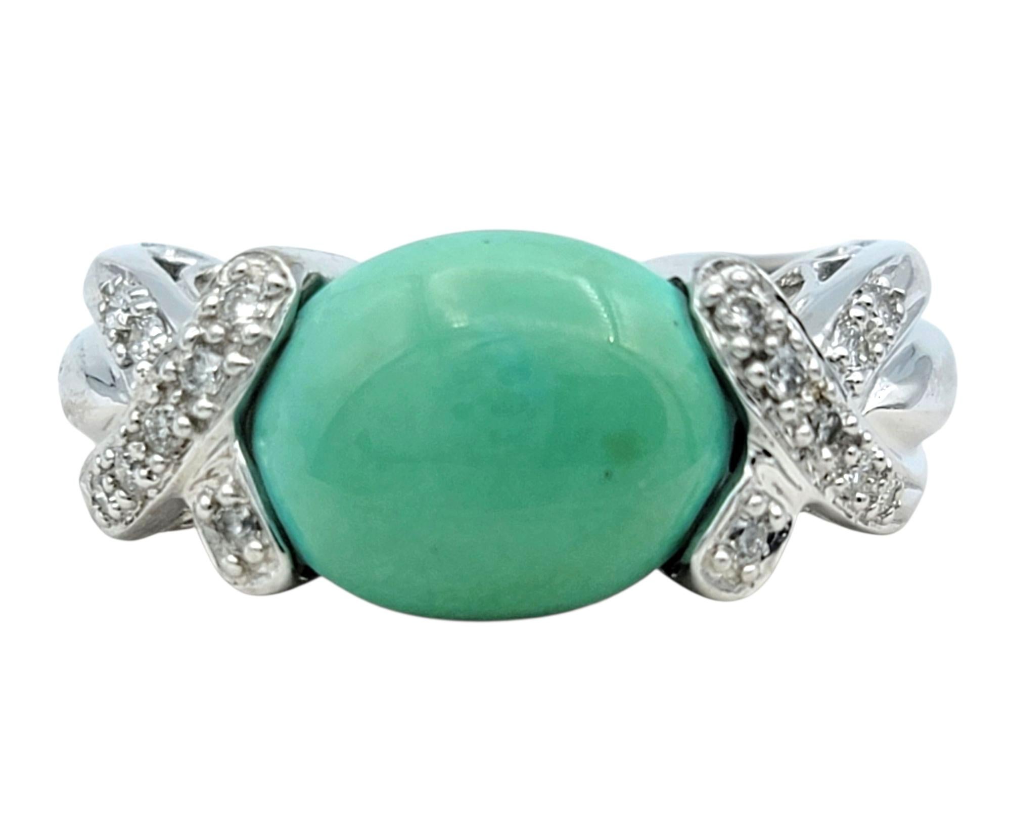 Ring Size: 6.75

A bold pop of color meets refined elegance in this turquoise and diamond ring. The centerpiece is a richly hued oval cabochon turquoise in a striking teal green shade, set horizontally for a modern look. Framing the turquoise on