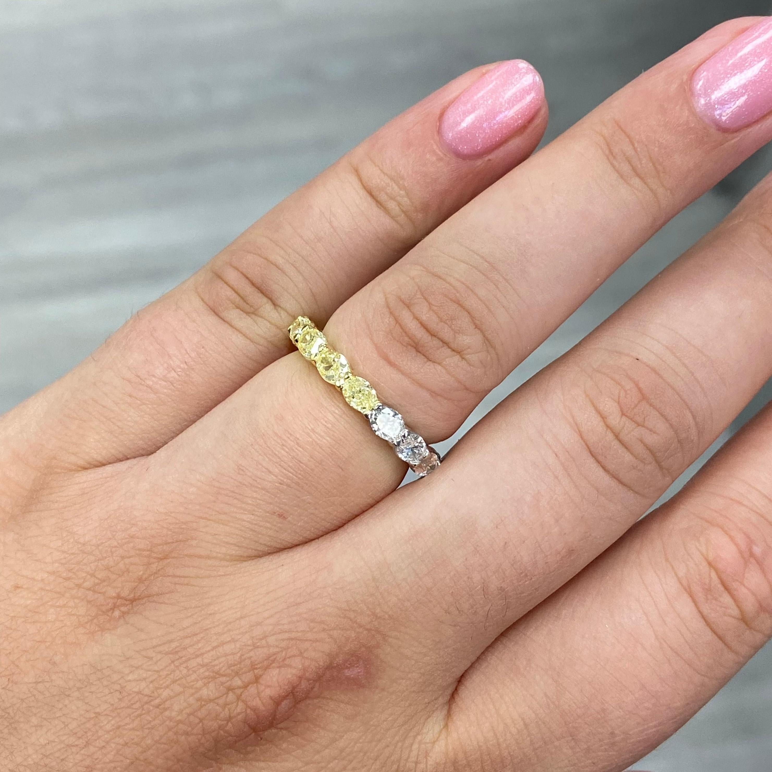 This stunning half and half east-west eternity band offers two diamond looks in one effortlessly chic design. Featuring 2.88 carats total of fancy yellow canary diamonds and E color white oval diamonds, each stone is set horizontally to create a