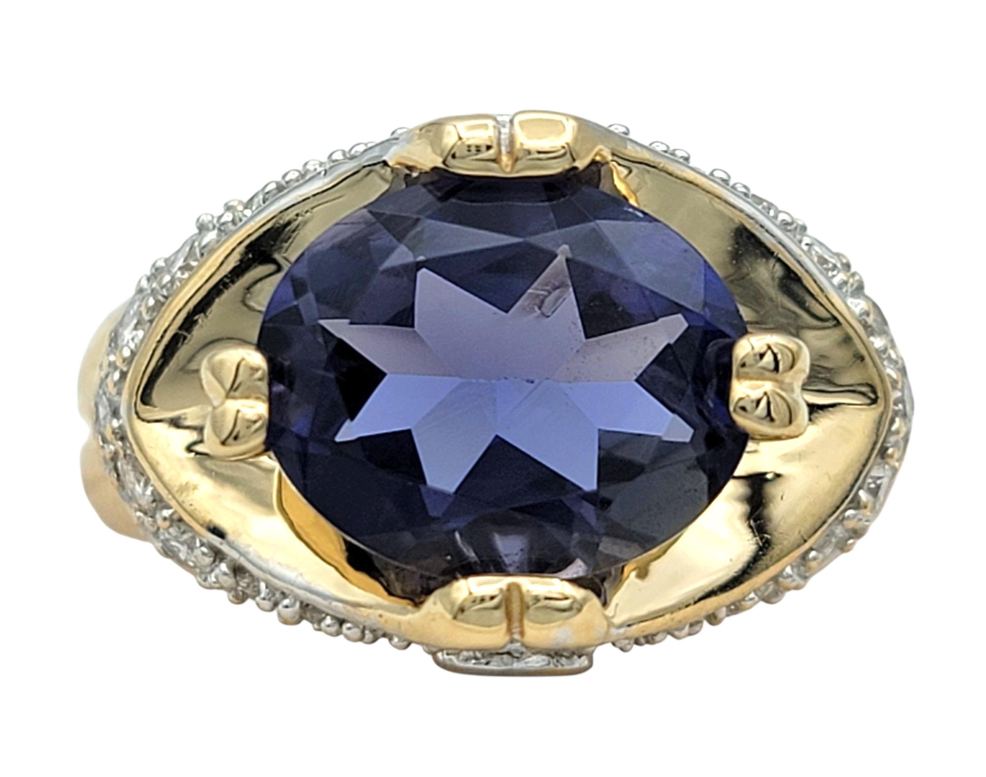 Ring Size: 7

This striking ring features a violet-blue iolite center stone, its deep, moody color enhanced by the graceful oval cut. The centerpiece is flanked by shimmering round diamonds on each side, adding a delicate contrast and highlighting
