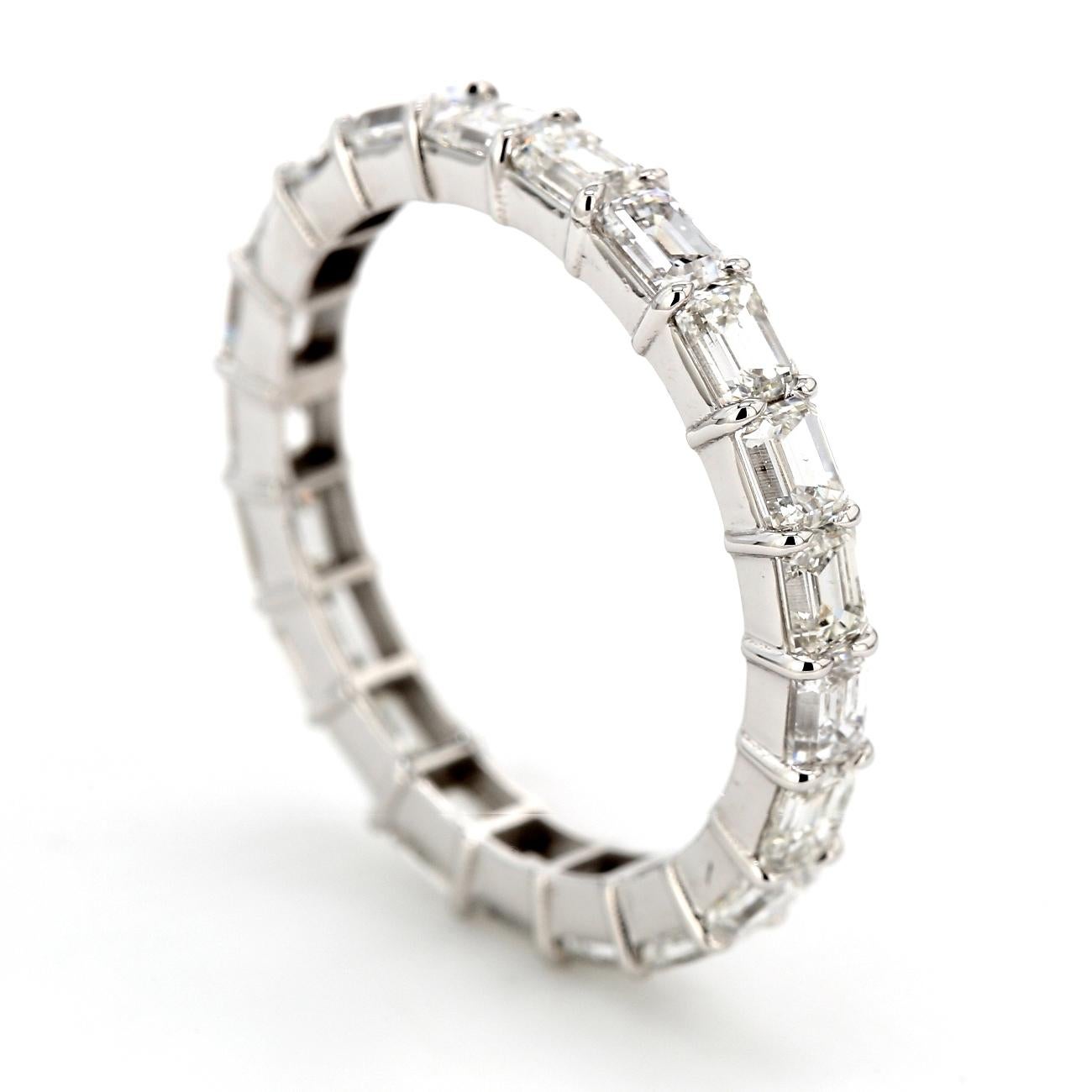 East-west style eternity band in 14K white gold with shared prong set emerald cut diamonds. D2.88ct.t.w.