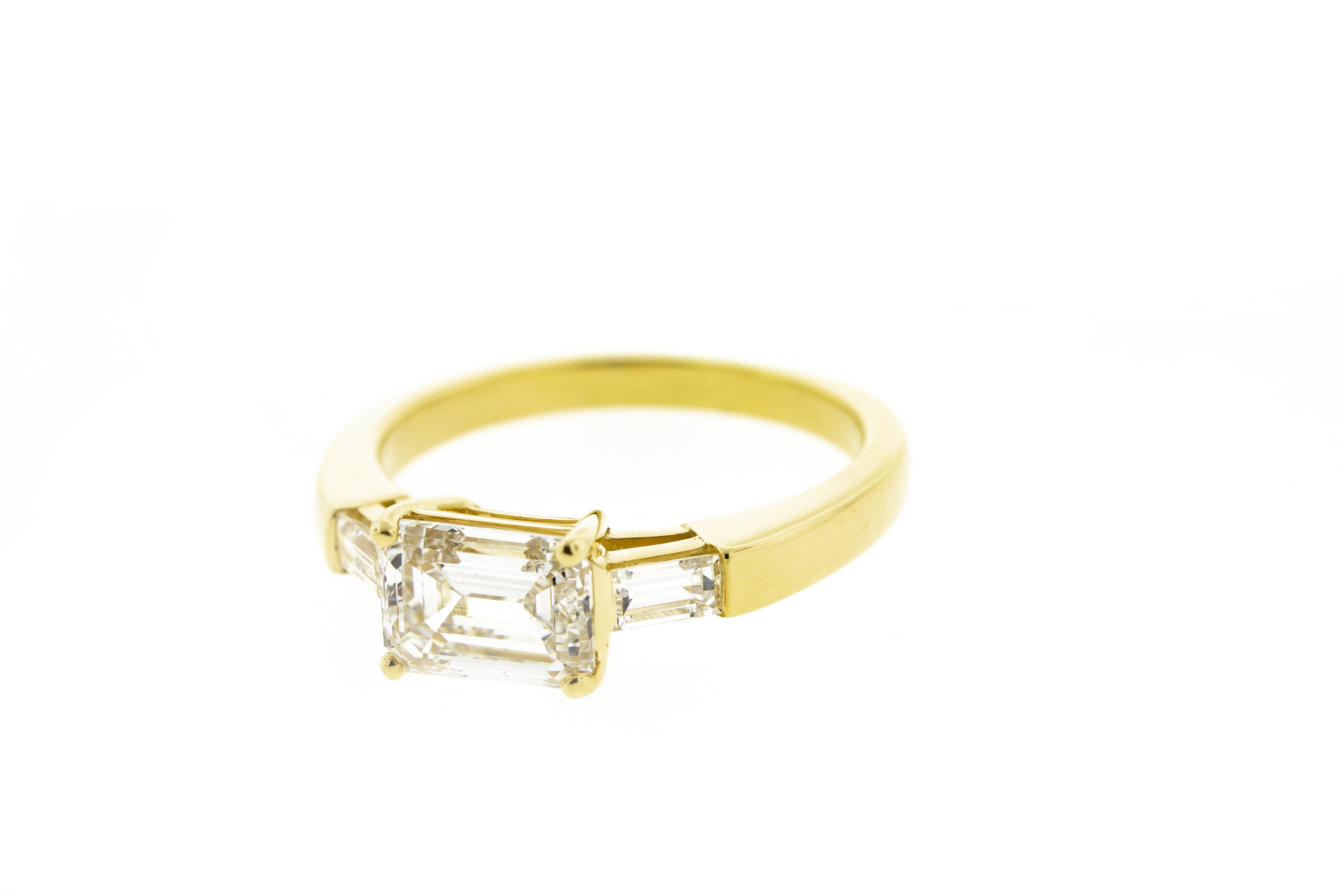 This three stone emerald cut diamond engagement ring is set in yellow gold. It features three emerald cut diamonds in an east-west orientation rather than the normal north south. It's a refreshing twist on a timeless classic. This ring can be