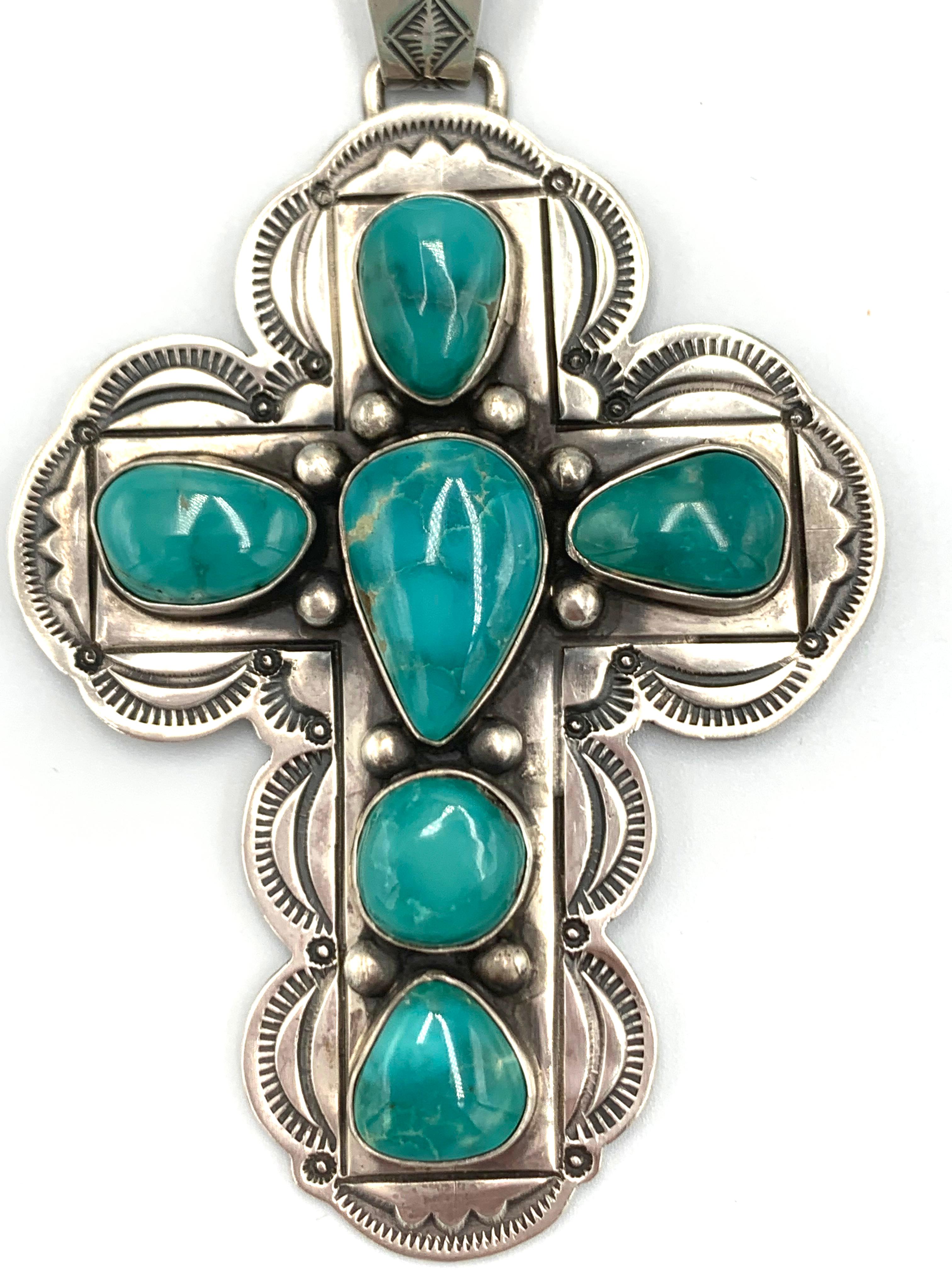 Questo ciondolo a forma di croce in argento sterling è stampato a mano e realizzato dall'argentiere Navajo Paul J. Begay. La croce misura 2¼
