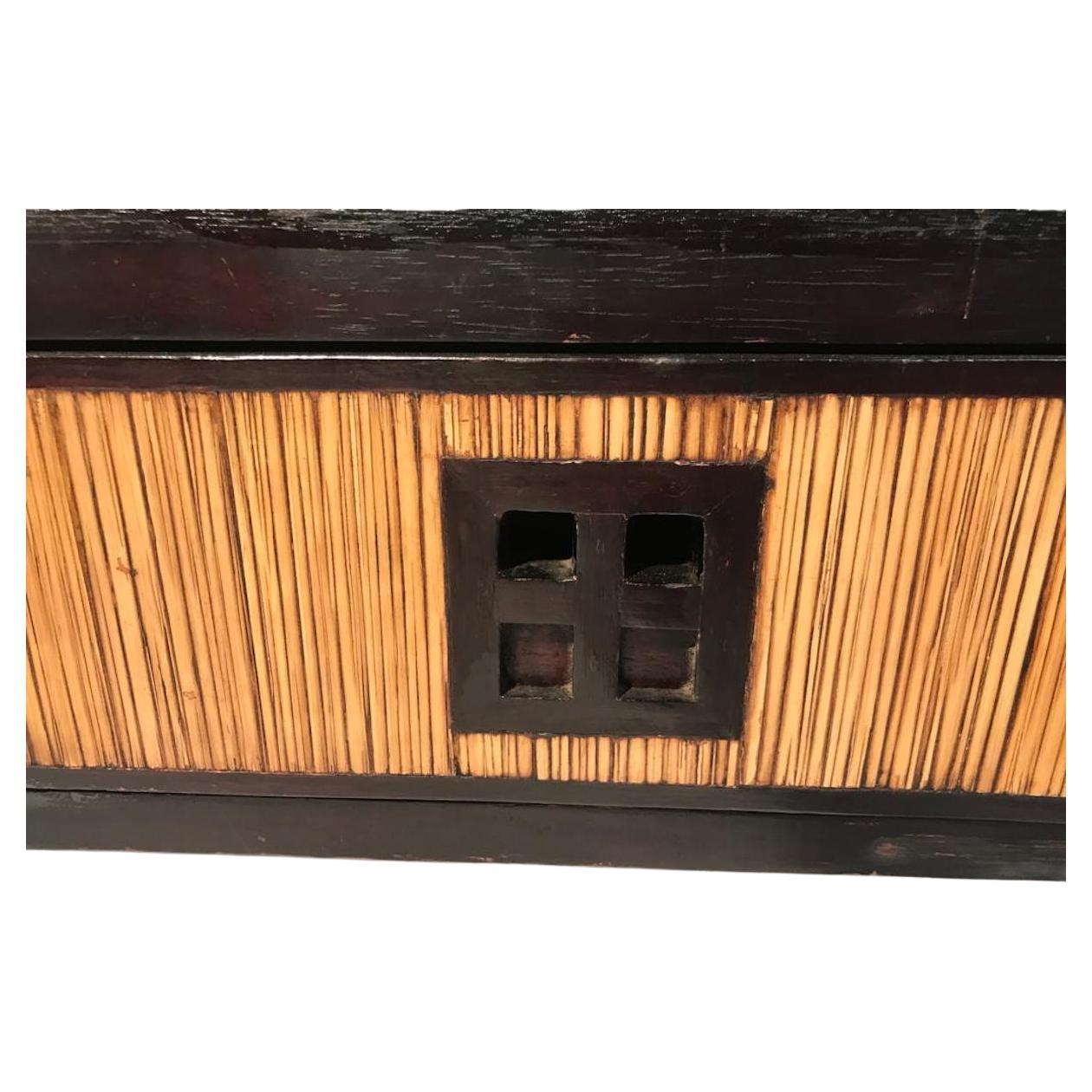 Gorgeous eastern consolle with double shelf also finished at the back. 
Made in Asia on 1960-1970,s in black lacquered wood and flat surfaces covered with straw. 
It has three drawers in the lower part. The drawers are finished with four holes that