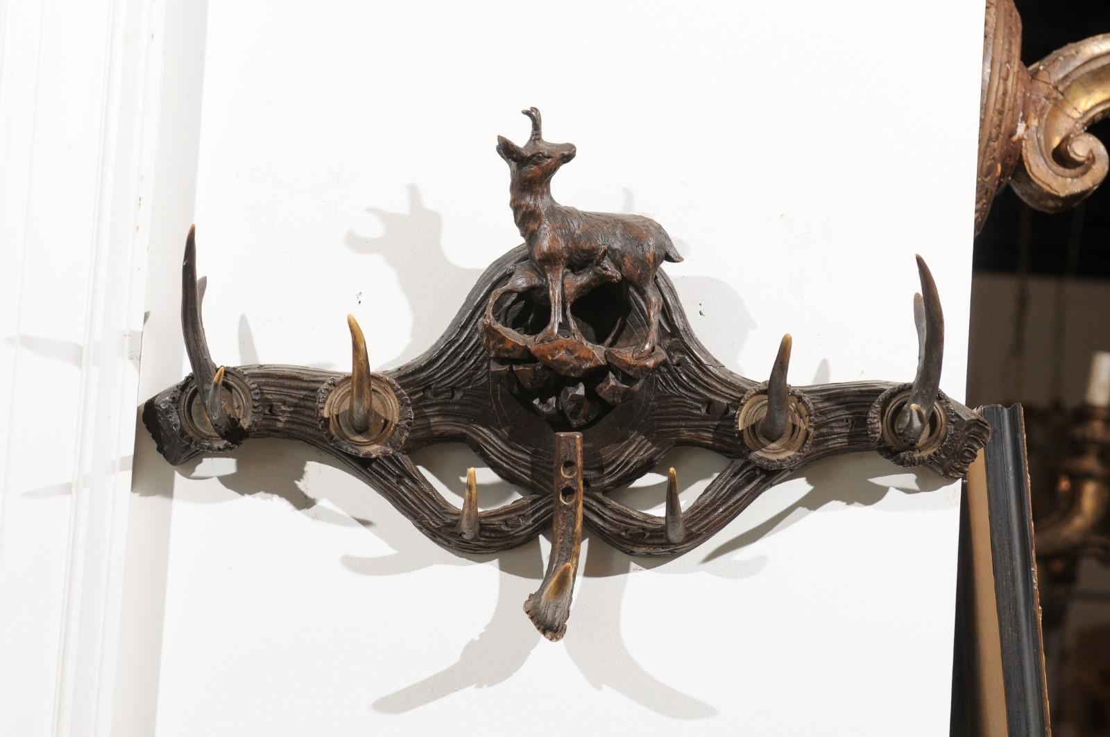 A French walnut hat rack from the 19th century, with hand carved chamois and her young. Born in Eastern France during the 19th century, this hat rack features a charming hand carved chamois, standing on a rocky formation. Her head turned backwards,