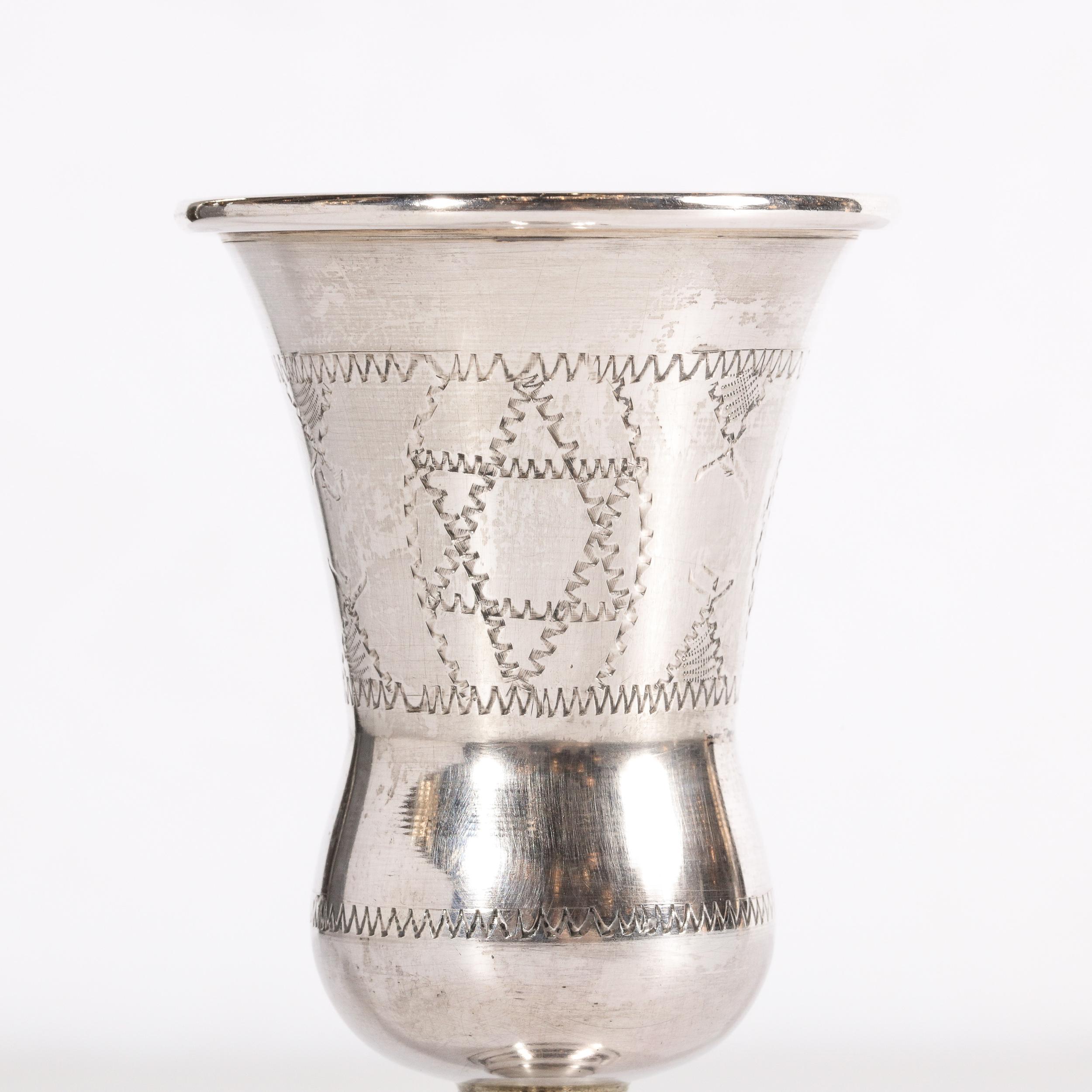 This beautiful ESCO (Eastern Sterling Company) .925 sterling silver Vermeil Kiddush Goblet Cup features a tiered base; a sinuously curved stem and a flared body with a circular mouth. It also offers hand chased patterns including a star of David