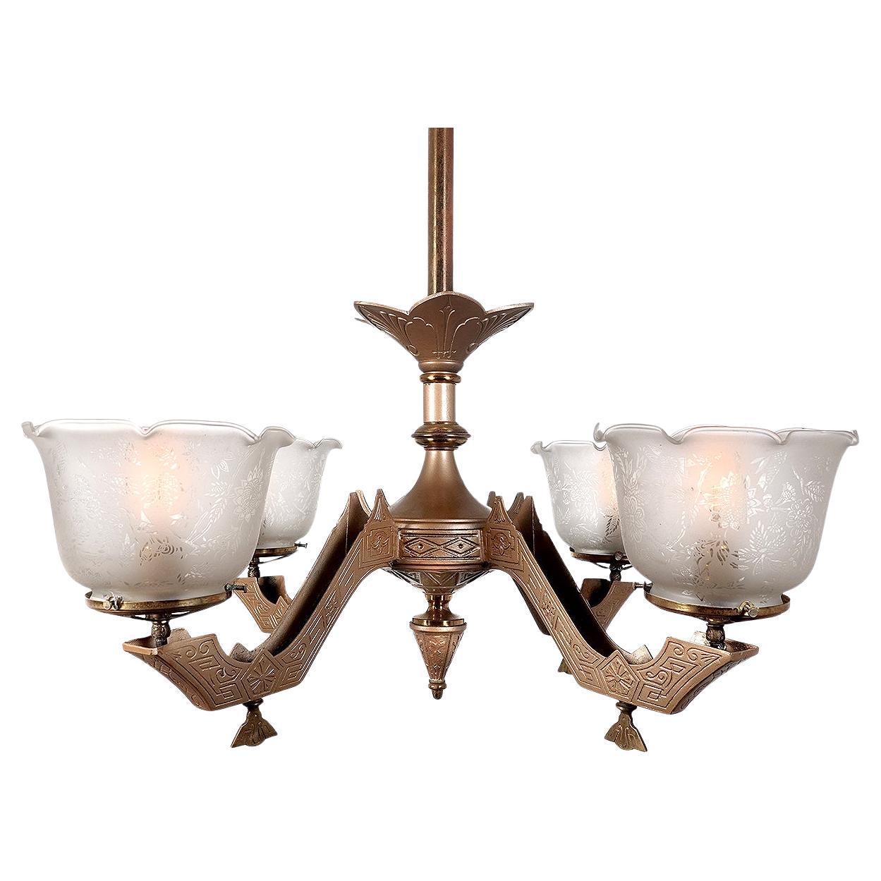 This is a nice original 4 arm Eastlake chandelier. All the original heavily etched floral pattern shades and gas keys are still there. We carefully wired the lamp to now take standard E26 bulbs and still keep the character of an early gas lamp. It’s