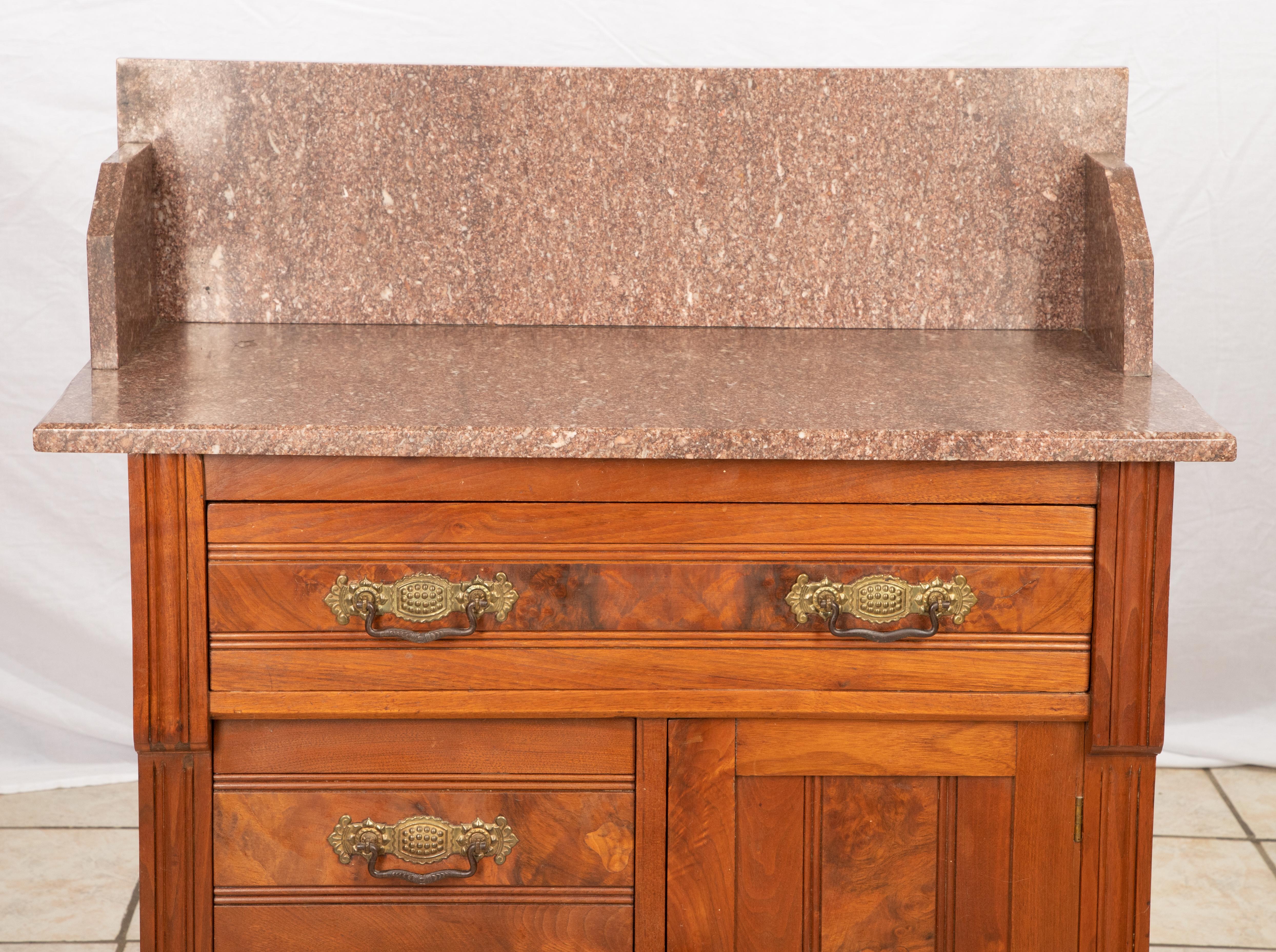 Offering this beautiful Eastlake marble-top wash stand. The wash stand is in a warm cherrywood and burled wood that is stained to a warm tone. The marble-top is a blush colored marble and has the high back. Has on long drawer over two smaller