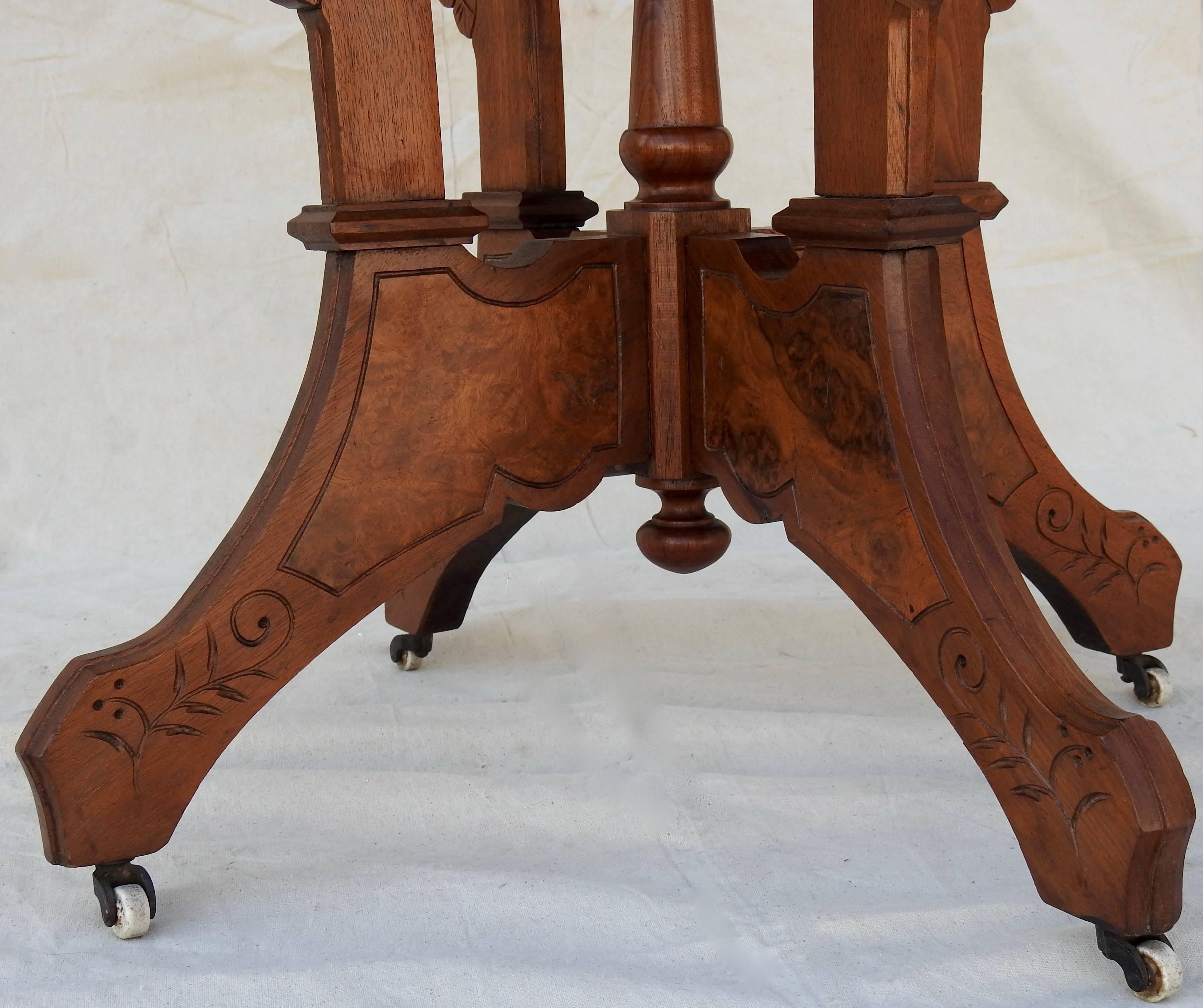 Offering this gorgeous Victorian burled walnut Eastlake table. The lightly carved wood is done in simple geometric patters with some foliate and scrollwork designs. There are four main legs that all meet in the center with a hand-turned spindle. The