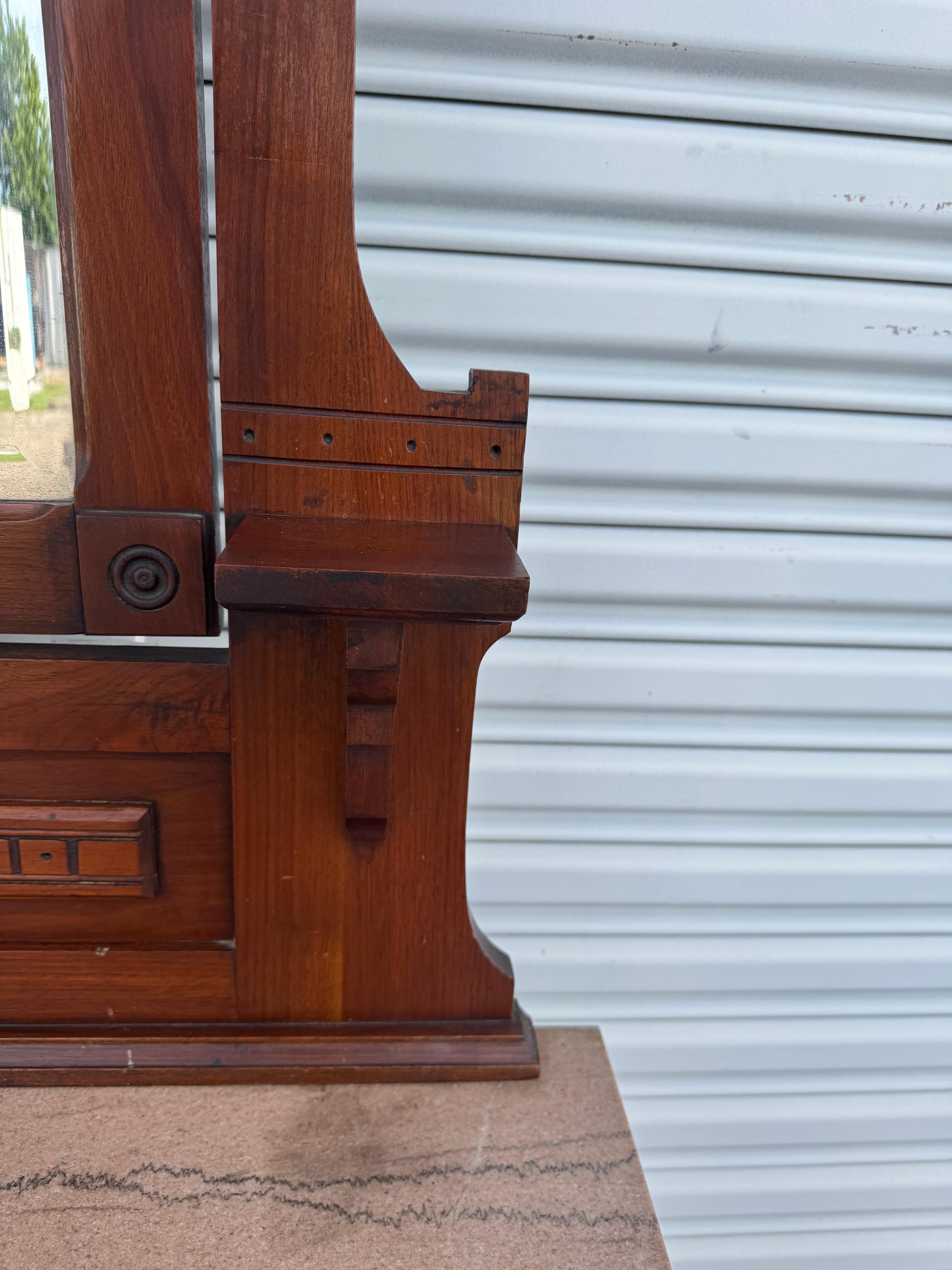 Cette superbe commode Eastlake avec miroir présente une facture victorienne classique, soulignée par des sculptures géométriques complexes et une finition en bois riche et chaude. Le plateau en marbre massif ajoute une touche luxueuse, tandis que