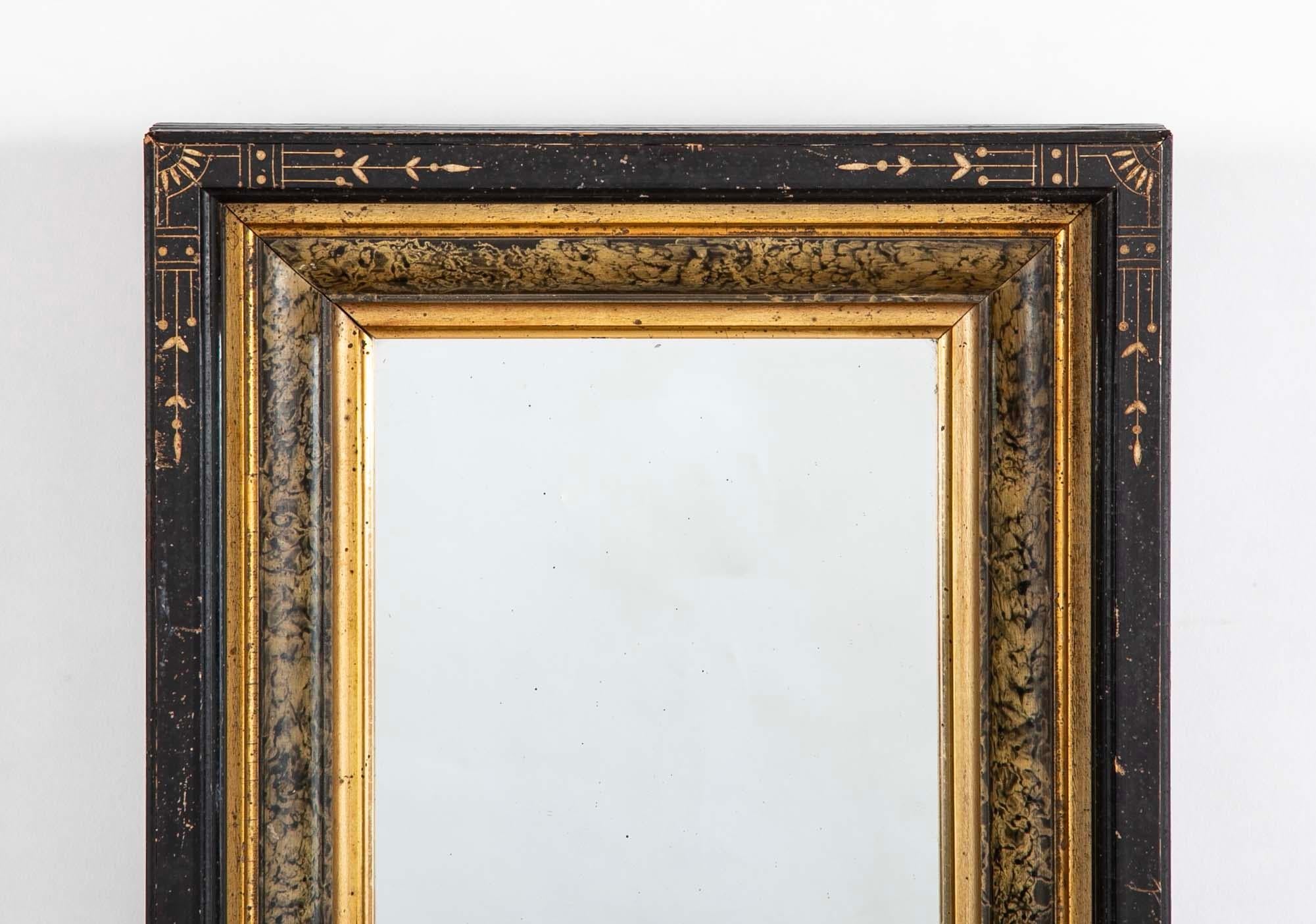 19th century Eastlake frame with mirror. The ebonized frame incised with stylized floral and geometric design typical of the Eastlake style. The two inner moldings gilt with a faux marble painted molding between. This is a small decorative mirror
