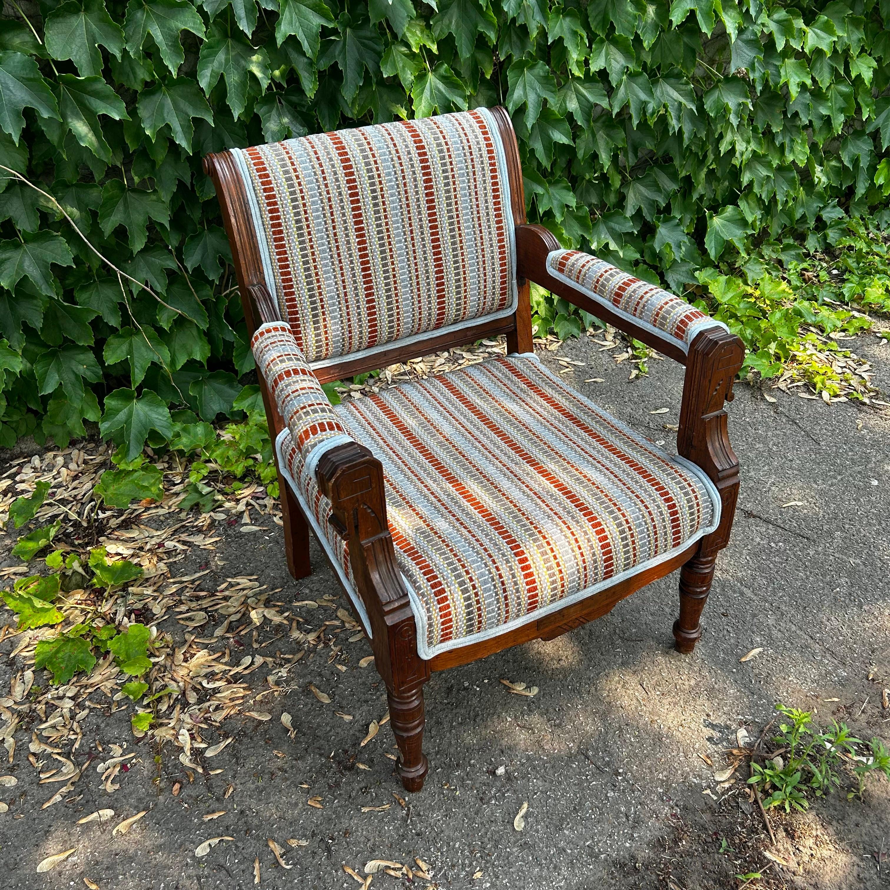 Curiously carved, this vintage wood-framed armchair deserved a great upholstery fabric to complement her Eastlake frame. Delicate geometry, shallow etchings, and a dark finish are iconic features of this style, which creates an eclectic and