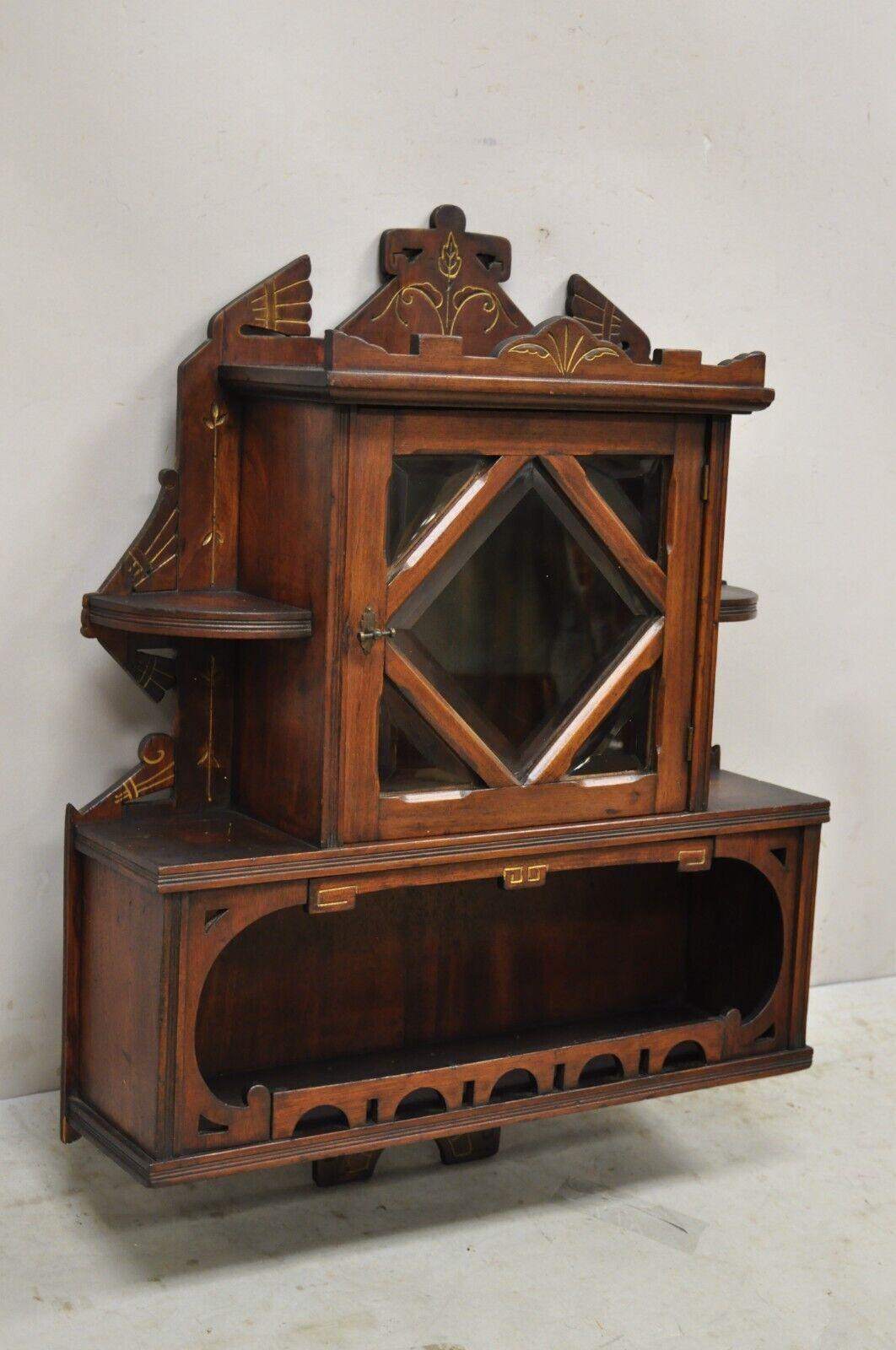 Antique Eastlake Victorian carved walnut wall display curio cabinet beveled glass door. Item features Beveled glass, lower interior shelf, beautiful wood grain, nicely carved details 1 swing door, very nice antique item, quality American