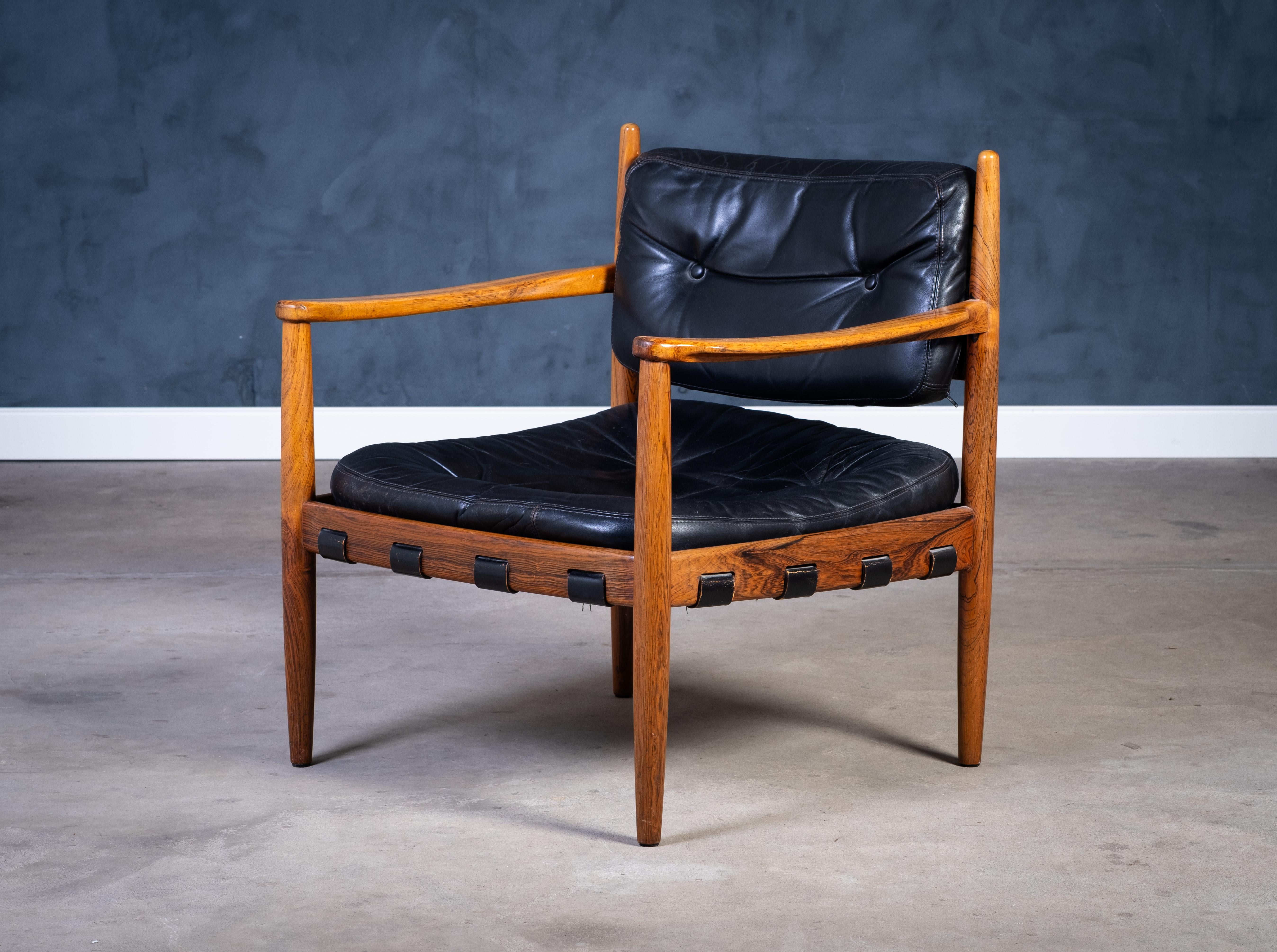 Elegante e confortevole poltrona da salotto disegnata da Eric Merthen e prodotta da Ire Möbel AB in Svezia negli anni '60. Realizzata in legno di palissandro con rivestimento in pelle nera, la sedia presenta una lavorazione finemente dettagliata e