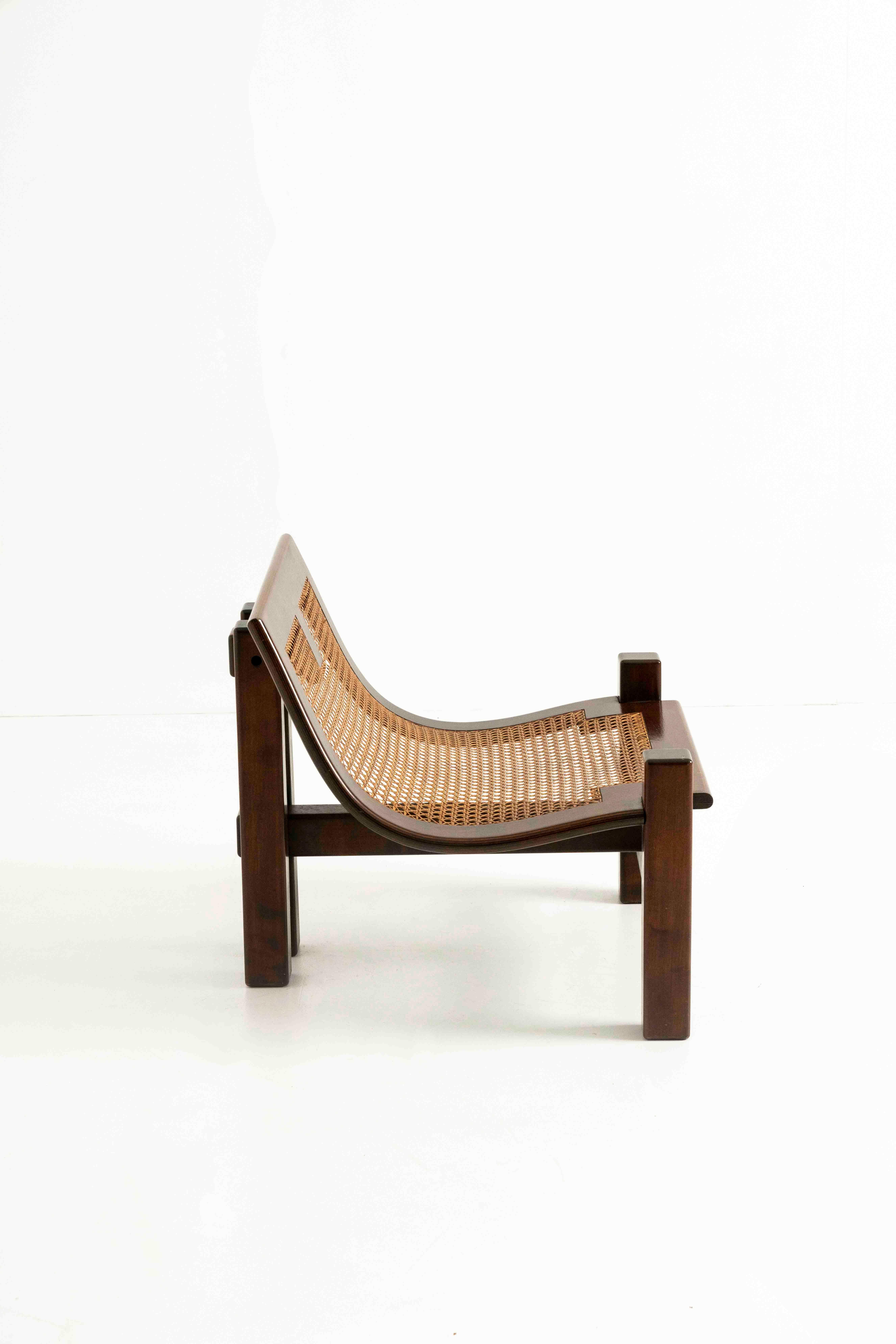 Stunning easy chair by Ferdinando Meccani in wood and cane from Italy 1960s. This chair has a great look and feel with an impressive design. The structure of the chair is made from wood and features a bent seating area and four asymmetrical legs.