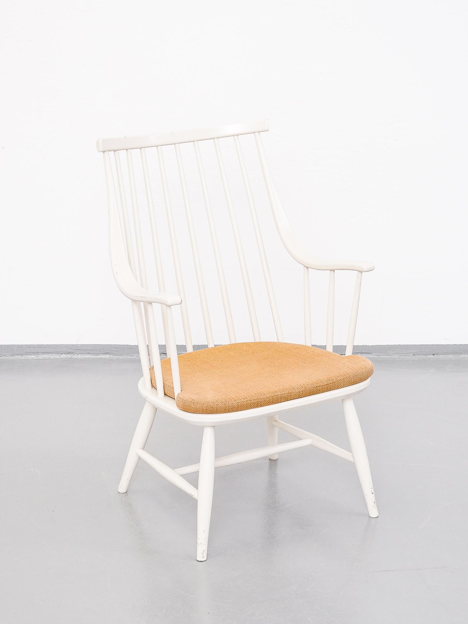 1960s Swedish spindle back easy chair by Lena Larsson for Nesto. Original white paint and cushion with yellow ochre fabric. Good condition, consistent with age and use.