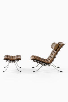 Sillón de cuero y acero con taburete de Arne Norell, años 70