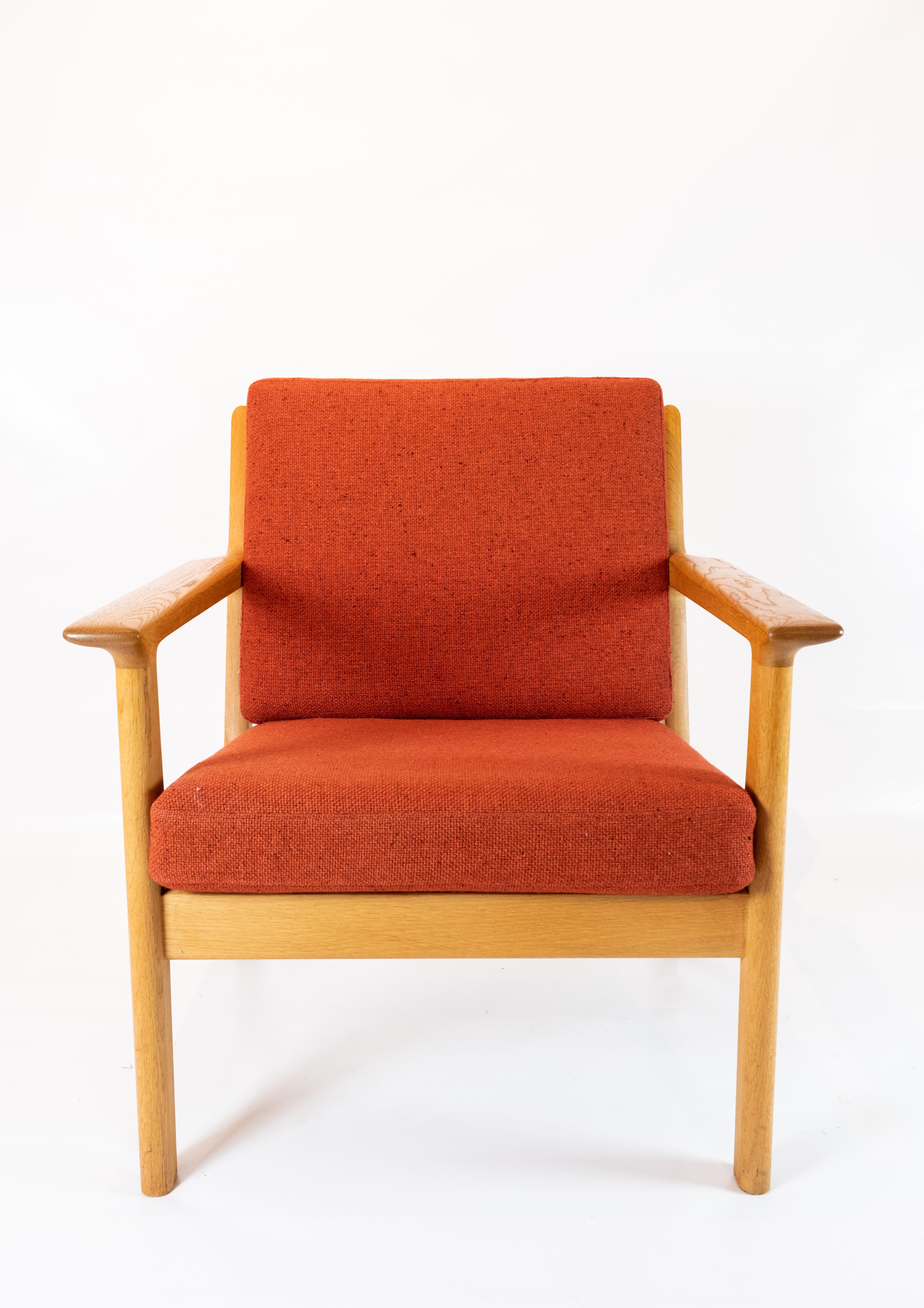 This easy chair, designed by the iconic Hans J. Wegner and crafted by GETAMA in the 1960s, epitomizes the timeless appeal of Scandinavian design. Constructed from solid oak and upholstered in a striking red wool fabric, it seamlessly blends comfort