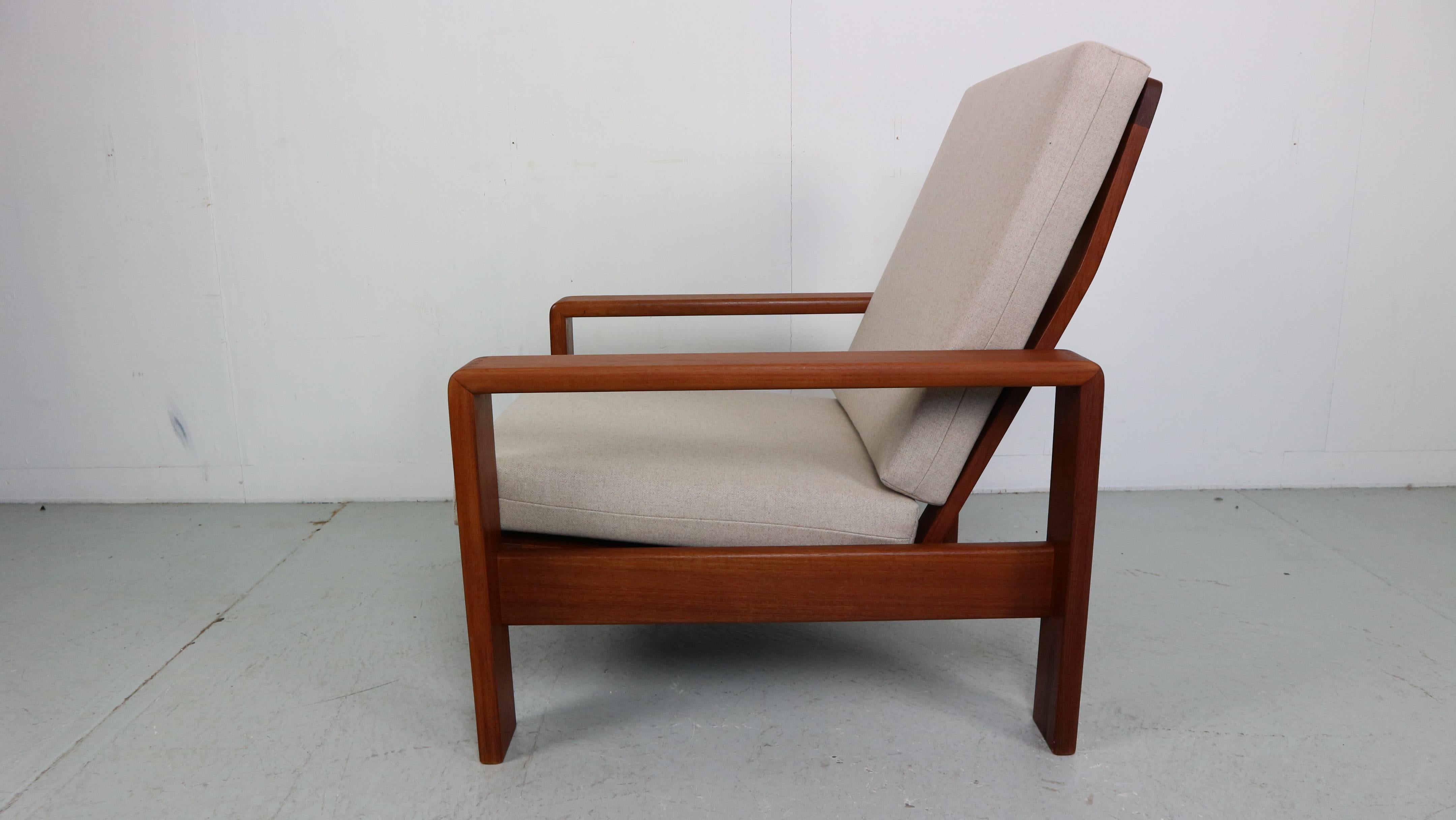 Stylish low easy chair designed and manufactured by EMC Møbler of Denmark in the 1960s. It has been reupholstered in a light beige and combines excellent with the warm teak color The fabric can be washed and the cushions can be used on both sides,