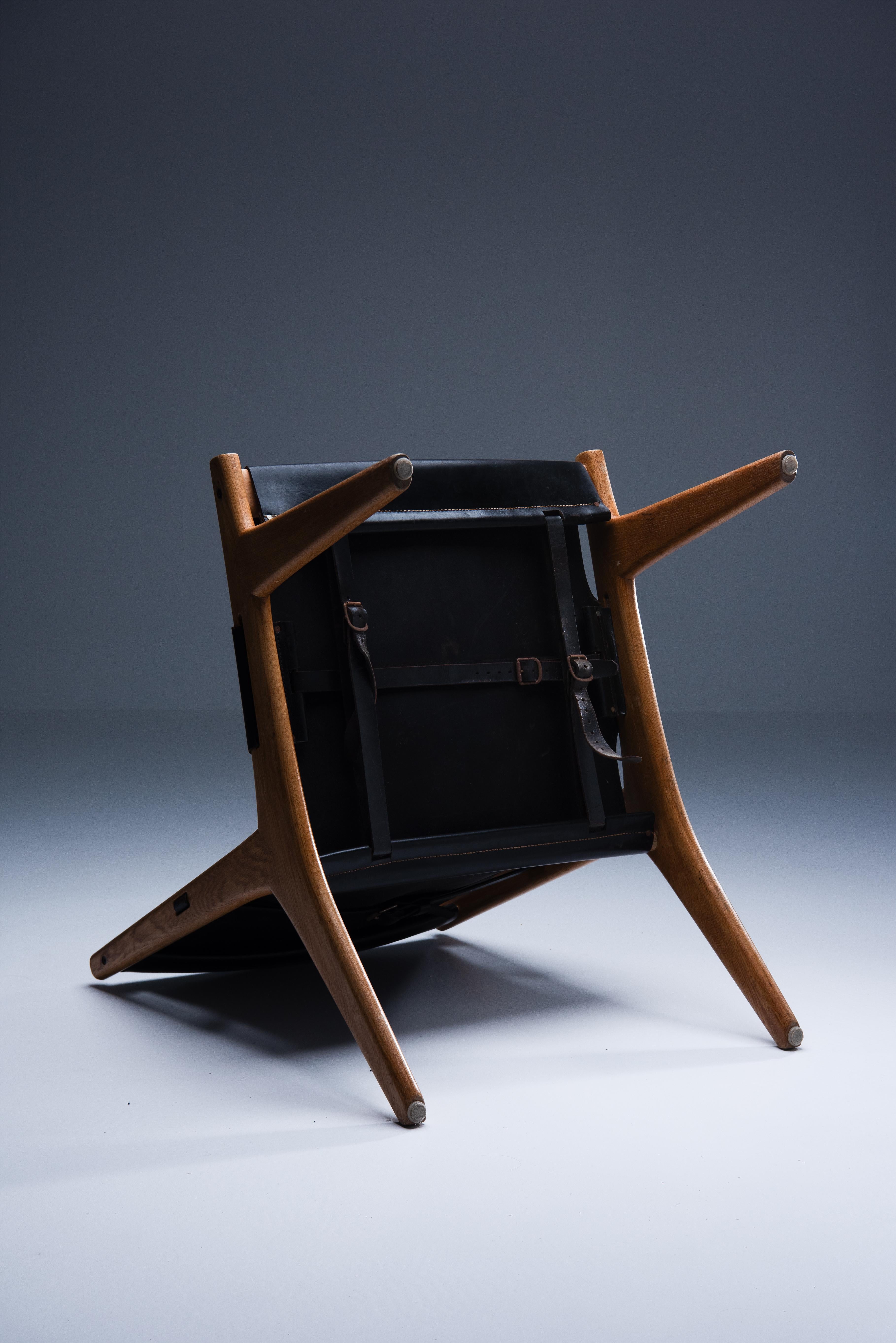 Swedish hunting chair designed by Uno & Östen Kristiansson in 1954 and manufactured by Luxus.
This quirky design is characterised by its minimalism. The use of a soaped oak frame combined with a black saddle leather seat and back gives the chair a