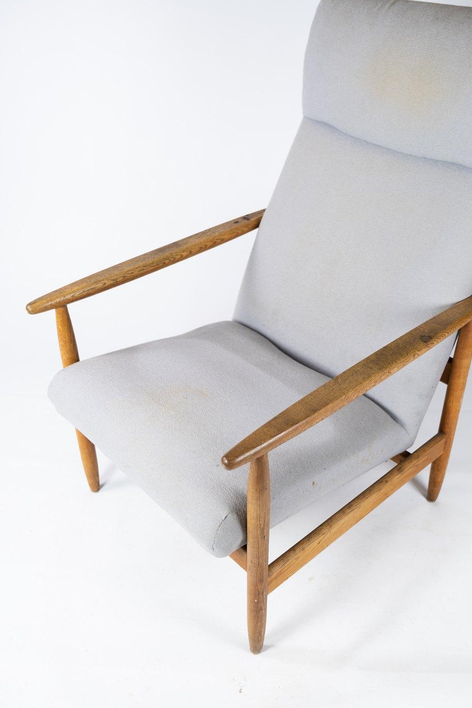 Easy chair, model J65 in light wood and upholstered with grey wool fabric designed by Ejvind A Johansson for FDB. The chair is manufactured by FDB in the 1960s.