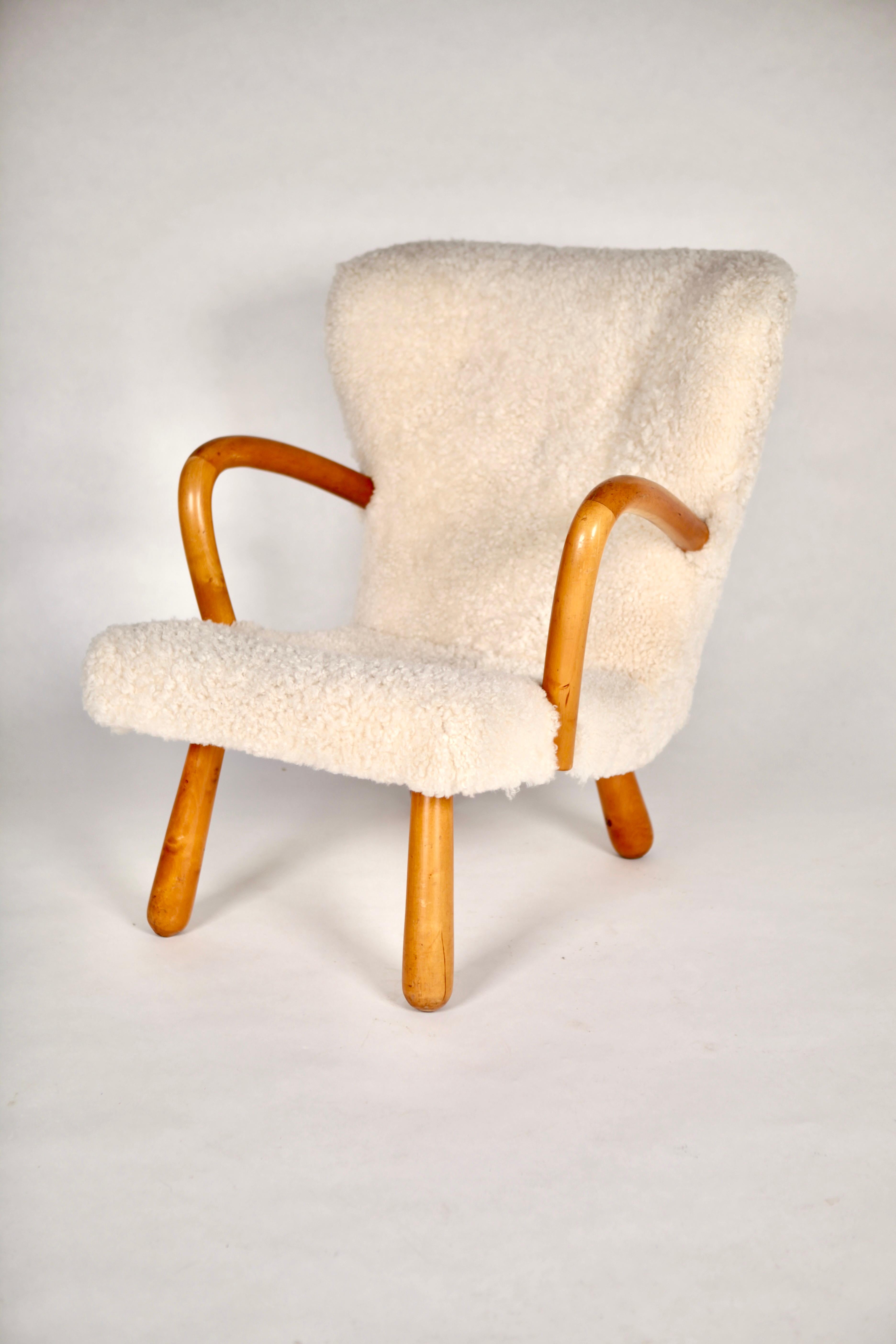 Clam chair, model Åke, cream colored shearling upholstered, legs and armrests in polished birch.
Manufactured by Ikea in Sweden in the 1950s. 
Great collectors item in excellent vintage condition.