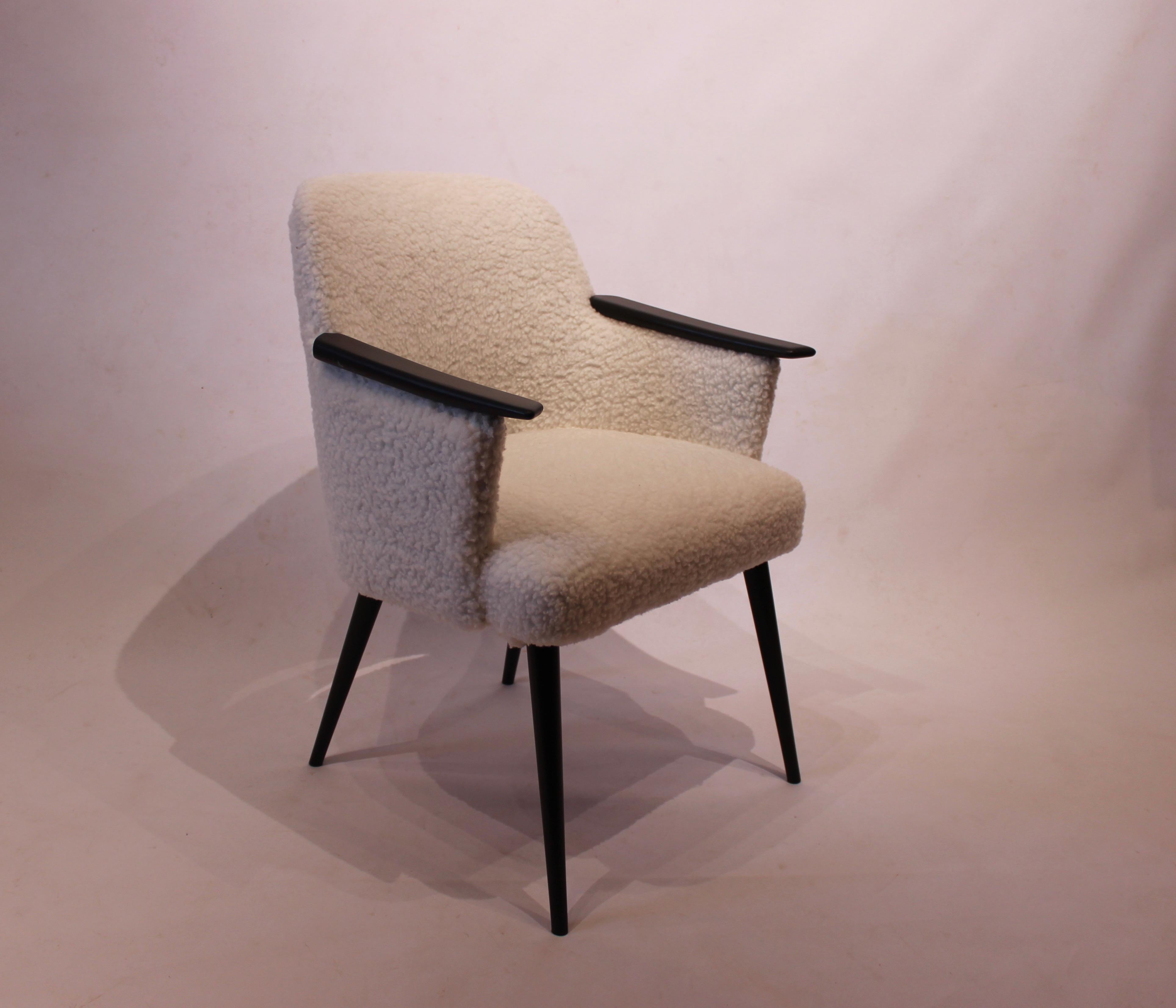 Easy chair upholstered in sheep wool and with arms of black painted wood of Danish design from the 1960s. The chair is in great vintage condition.