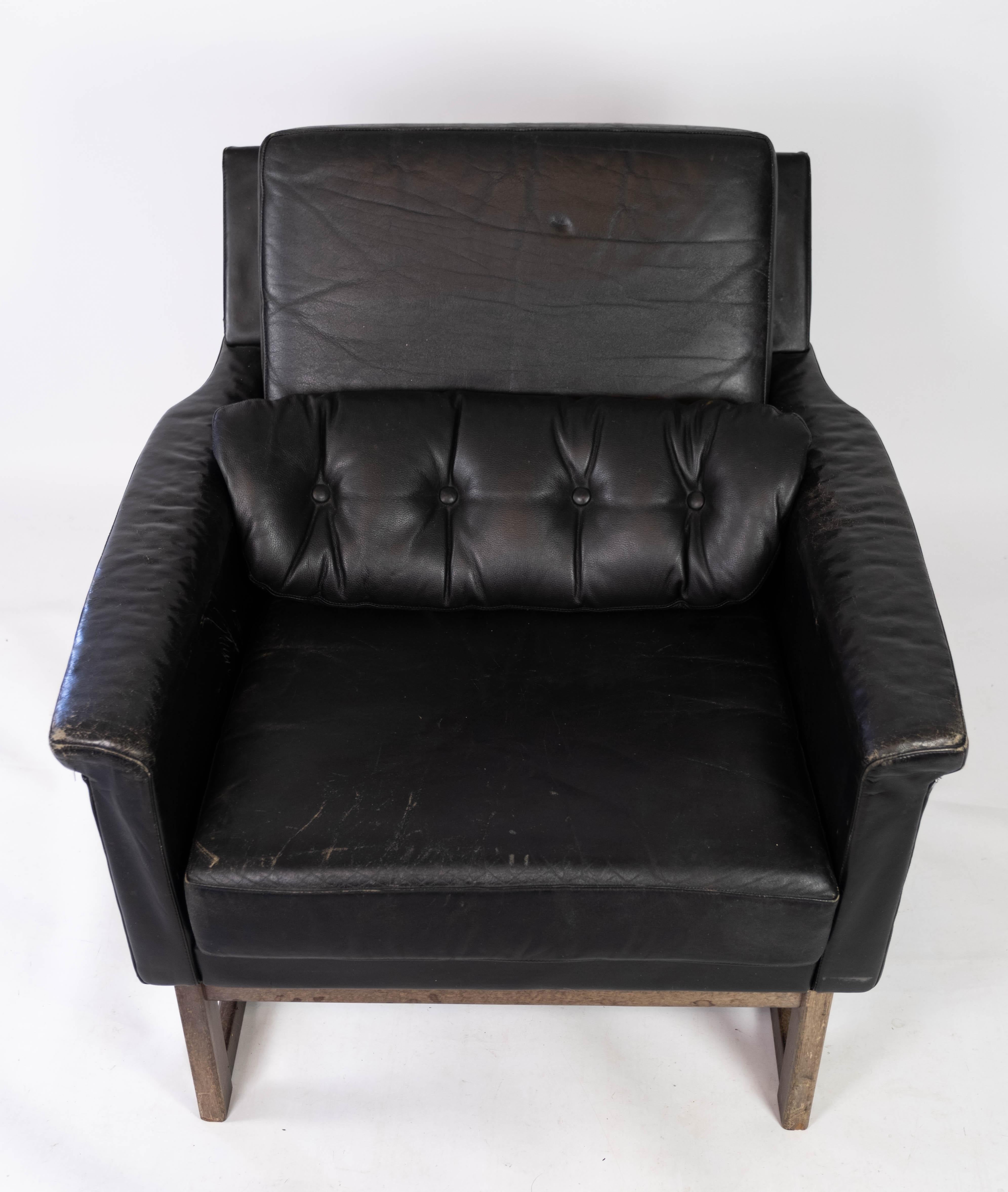 Easy chair upholstered with black leather and legs in wood, designed by Illum Wikkelsø from the 1960s. The chair is in great vintage condition.