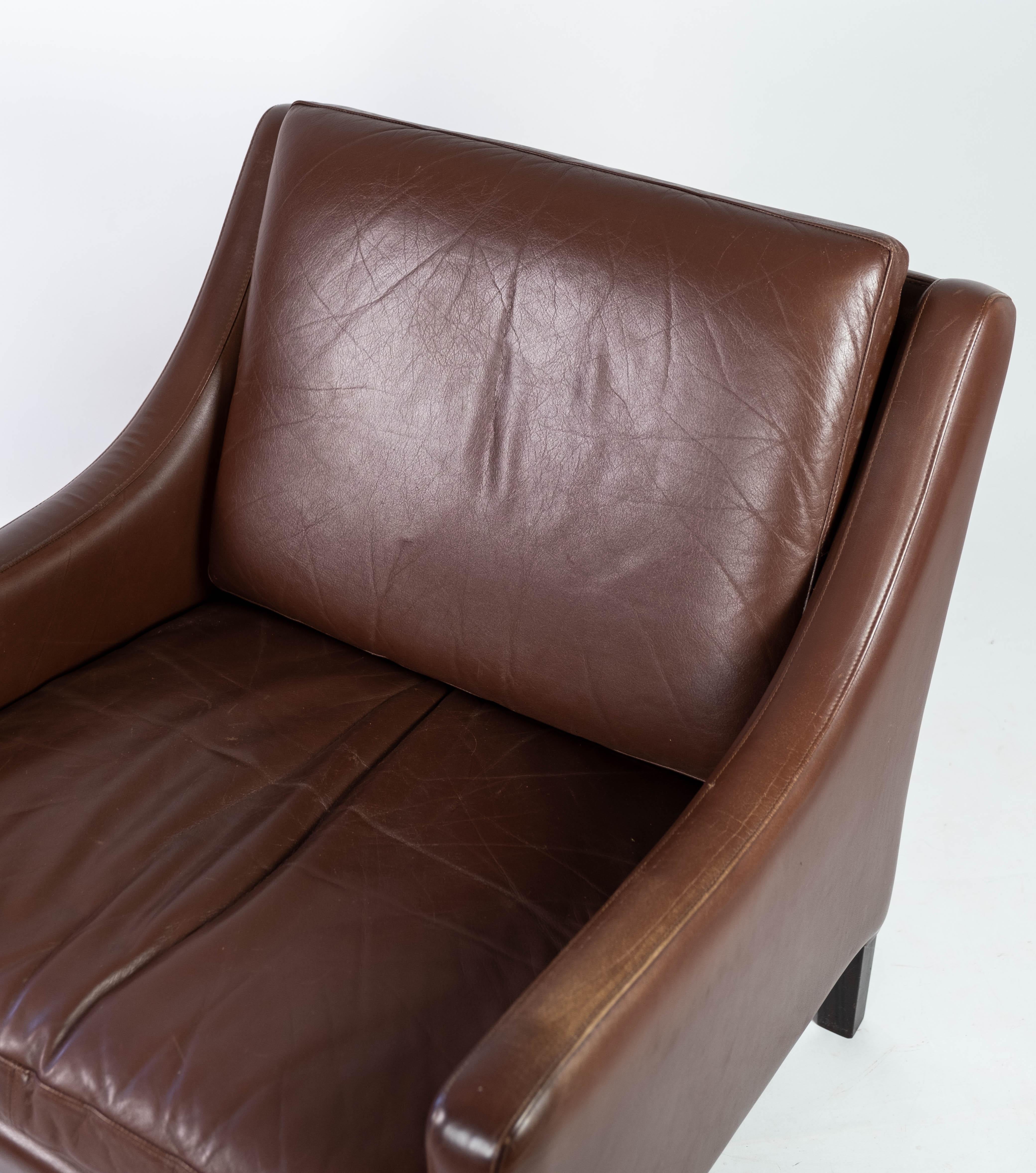 Easy chair upholstered with dark brown leather and legs of dark wood, of danish design from the 1960s. The chair is in great vintage condition.