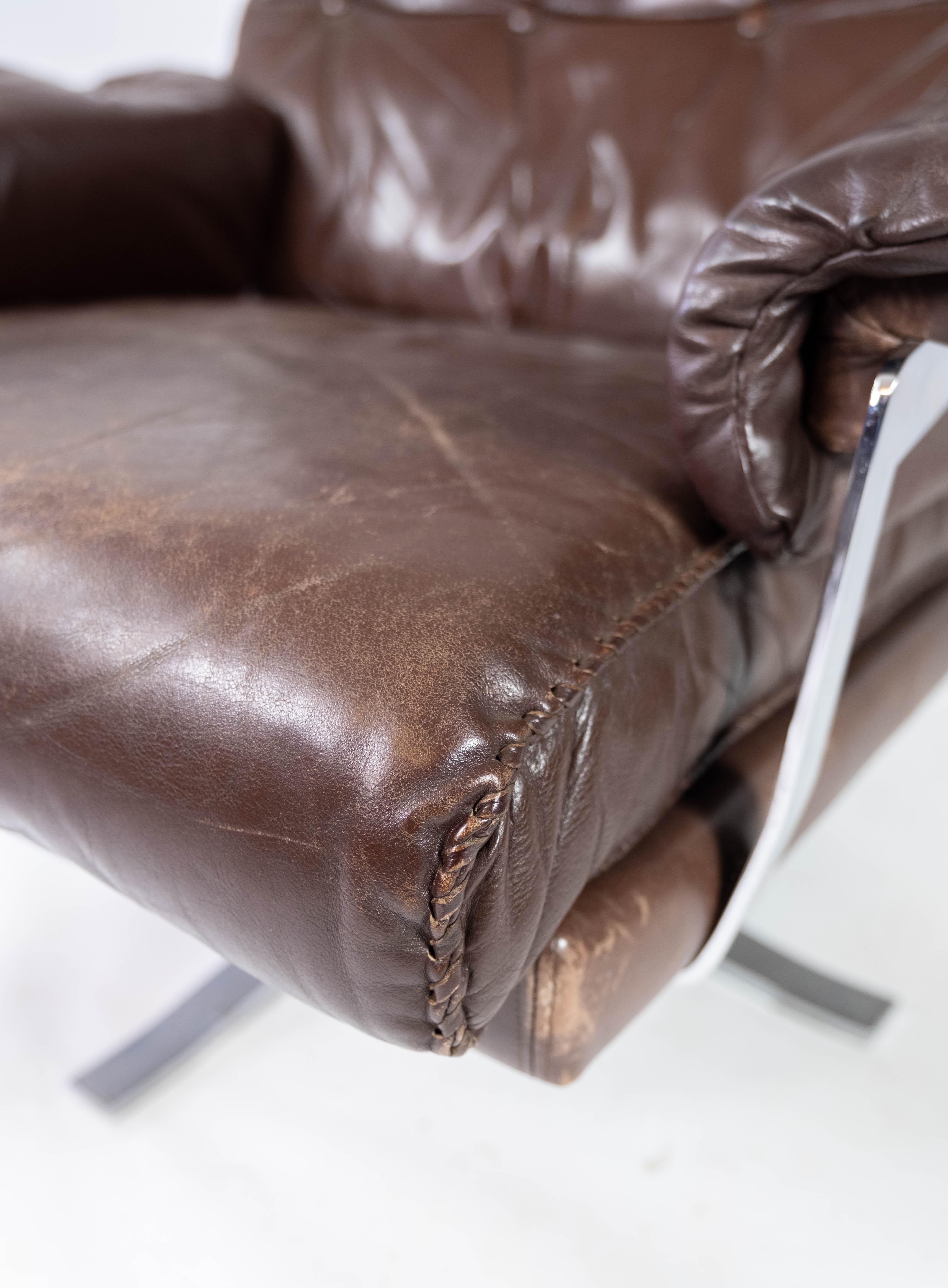 Dieser Sessel aus patiniertem braunem Leder und Metallgestell ist ein zeitloses Möbelstück, das von dem bekannten schwedischen Designer Arne Norell entworfen und von Vatne Møbler in den 1970er Jahren hergestellt wurde.

Arne Norell war bekannt für
