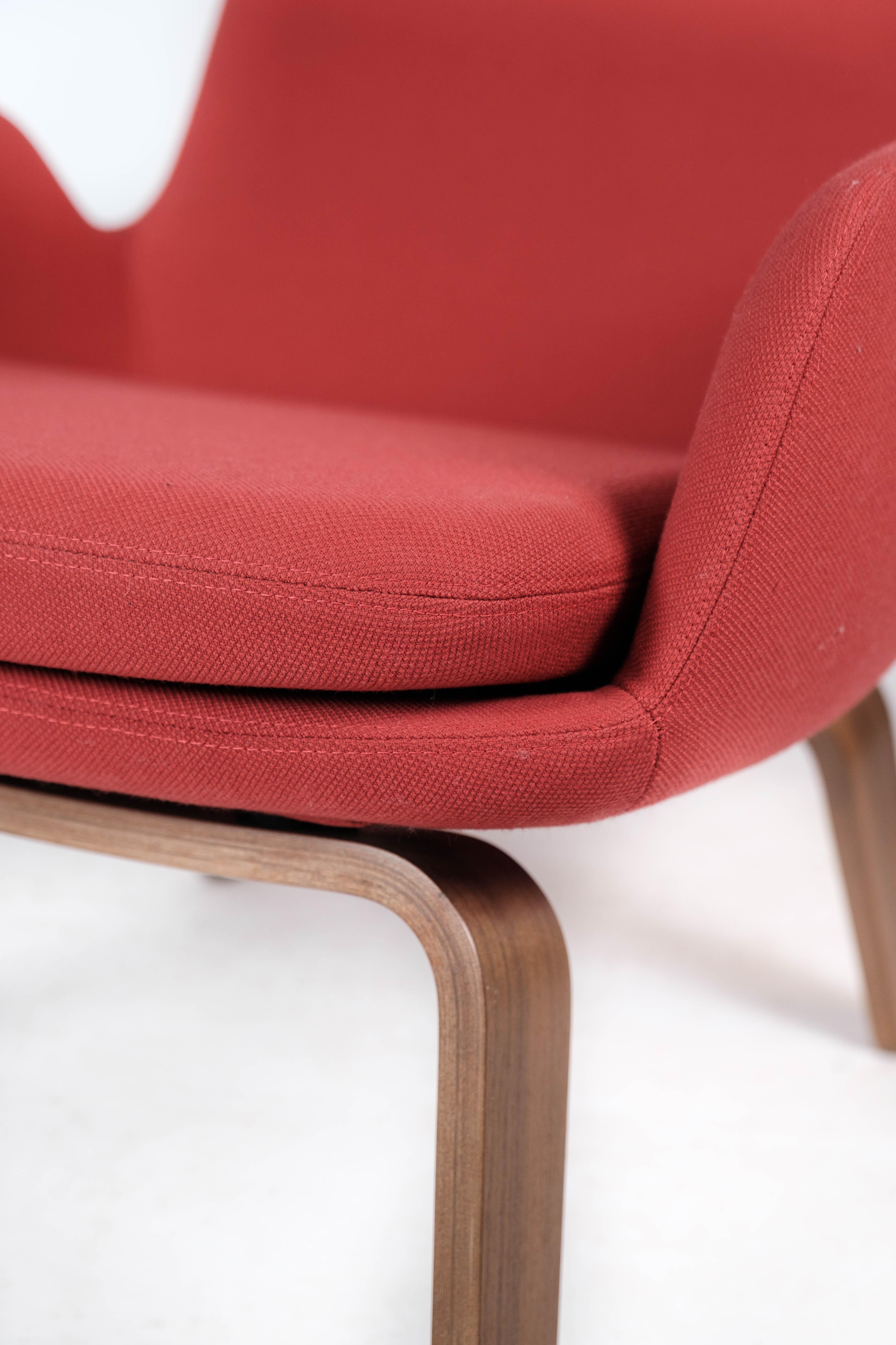 Easy chair with legs of walnut and upholstered with red fabric of Danish design for Normann Copenhagen. The chair is in great used condition.