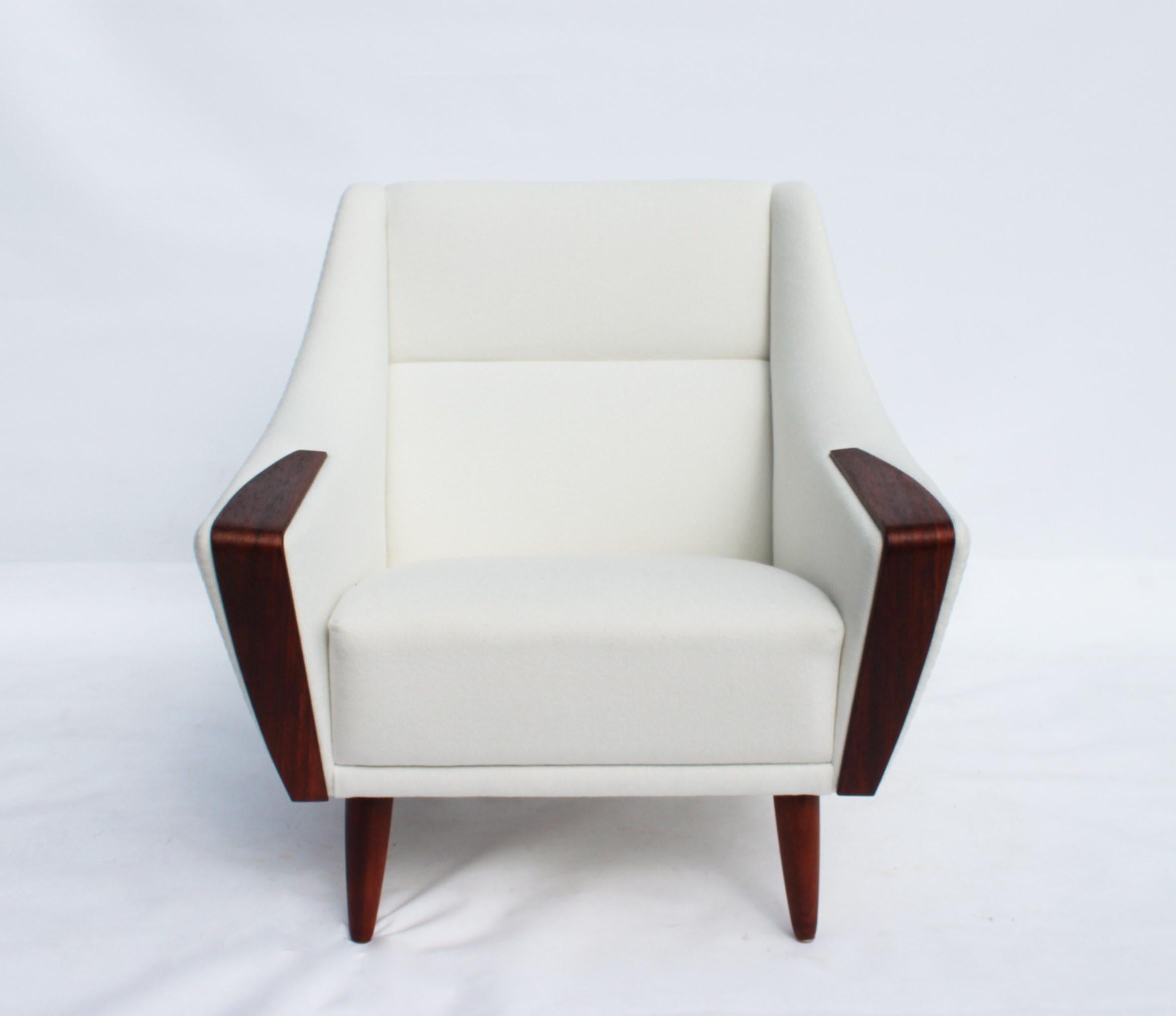 The armchair with a low back, upholstered in an elegant white fabric and resting on beautifully polished rosewood legs, is a masterpiece of Danish design from the 1960s. Its clean lines and organic form reflect the period aesthetics of Scandinavian