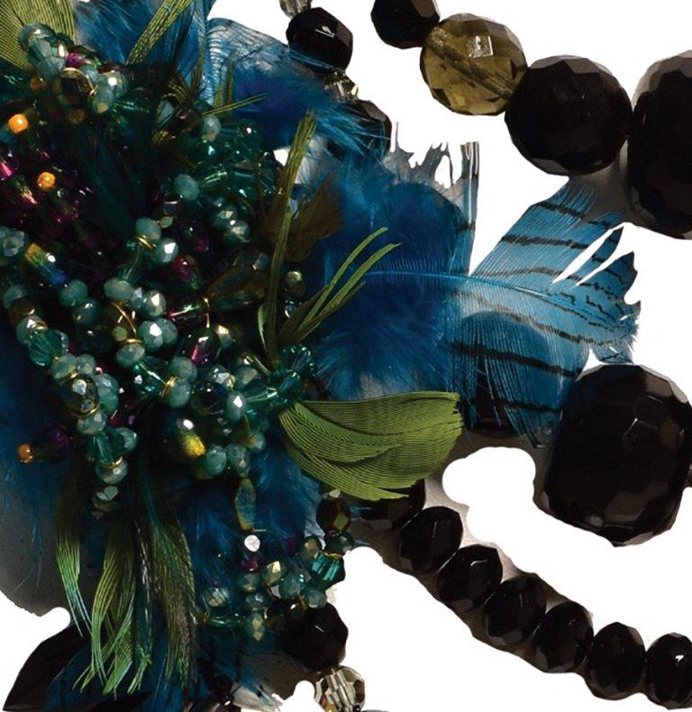 An over-the-top, exquisitely crafted 5-strand necklace.
It's a mix of Onyx, faceted black glass, smoky grey semi-precious beads along with blackened metal spike pendents. 
3 'stations' of artisanal woven beads and feathers (all three are distinct)