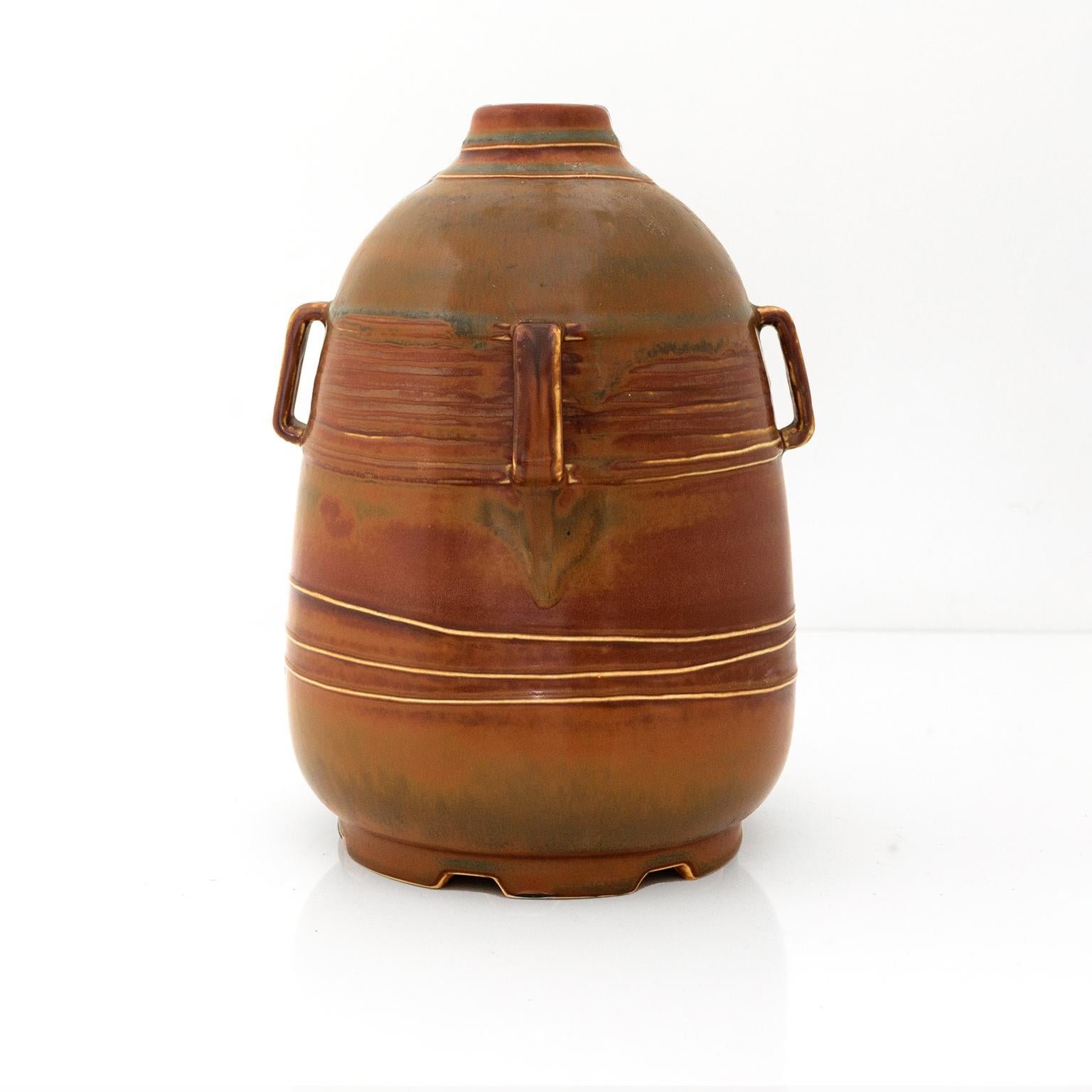 Ebbe Sadolin, unique stoneware vase in a brown and gold glaze, detailed with four “handles”, wavy horizontal raised lines and a notched footed base. Signed ES, stamped maker's mark, 104 and u720. Made in Denmark c. 1940s.
 
