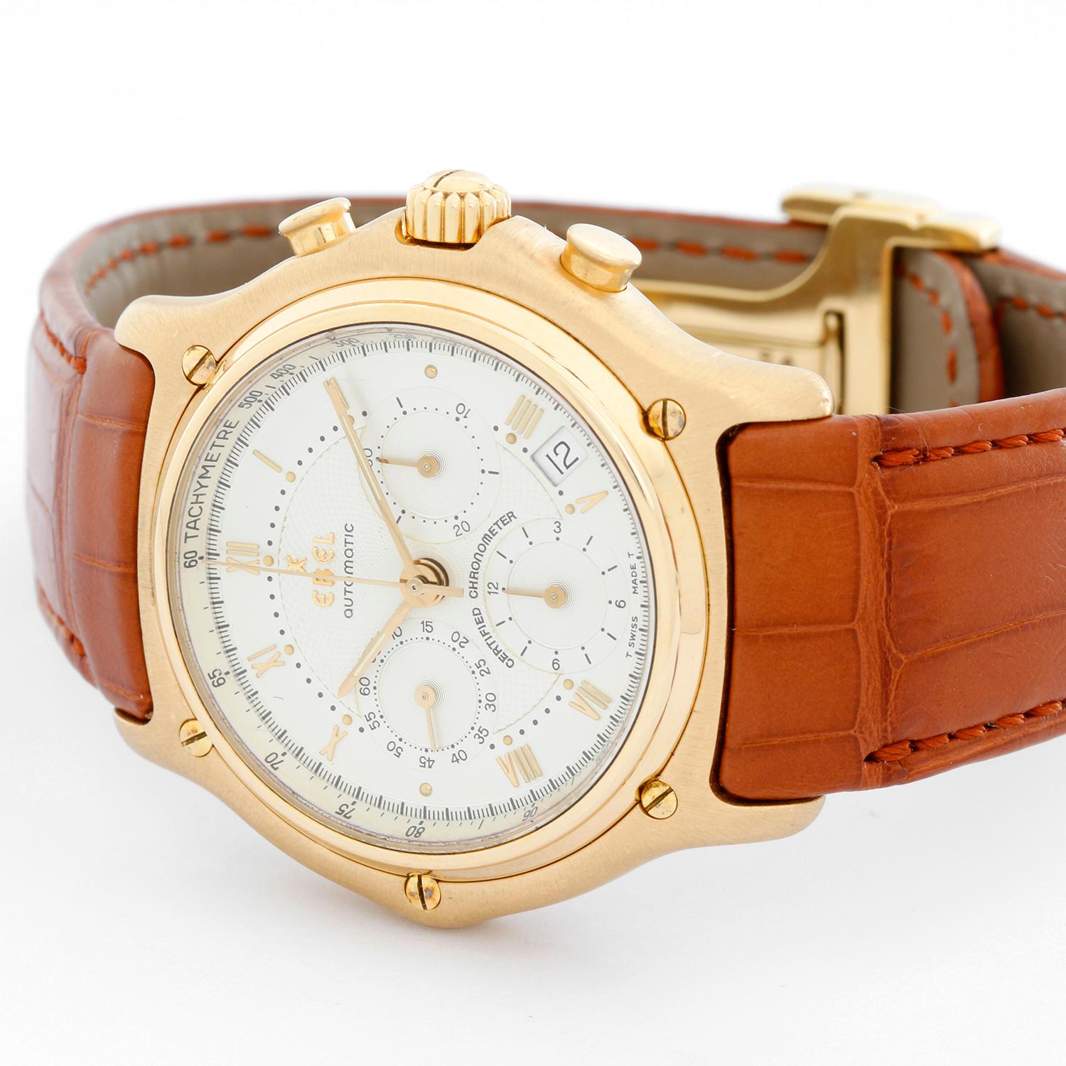 Ebel 1911 Chronograph Men's Watch - Automatic. 18k yellow gold case with 18K yellow gold bezel. White dial with gold Roman numerals. Leather strap with 18k yellow gold deployant clasp. Pre-owned with custom box.