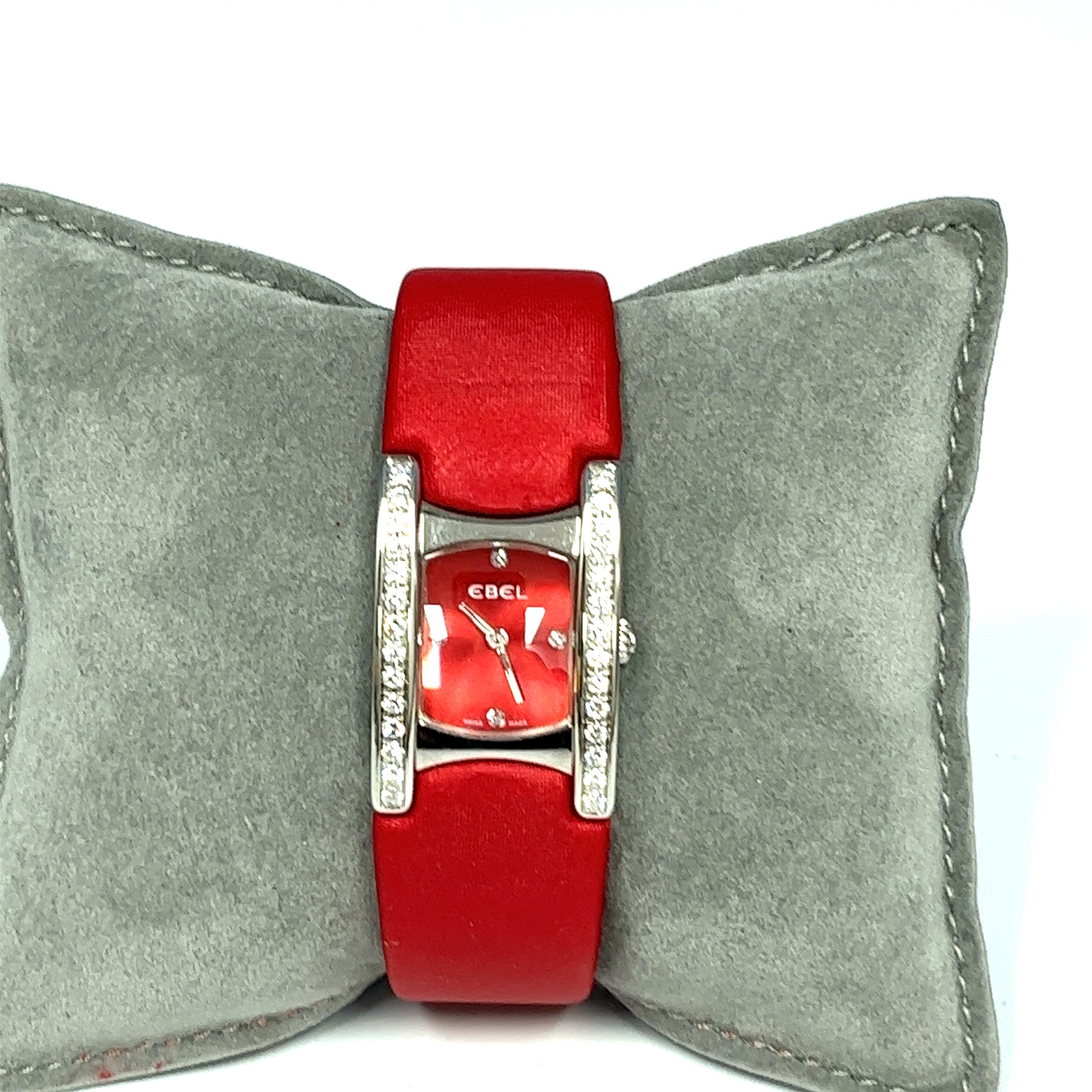 Ebel is a Swiss luxury watch company and was founded in 1911 in Switzerland. This beautiful pre owned Ebel Beluga E 9057A28-10 has a stainless steel case with a red dial. It has stainless steel hands and diamond numeral markers at 12, 3, 6 and 9. It