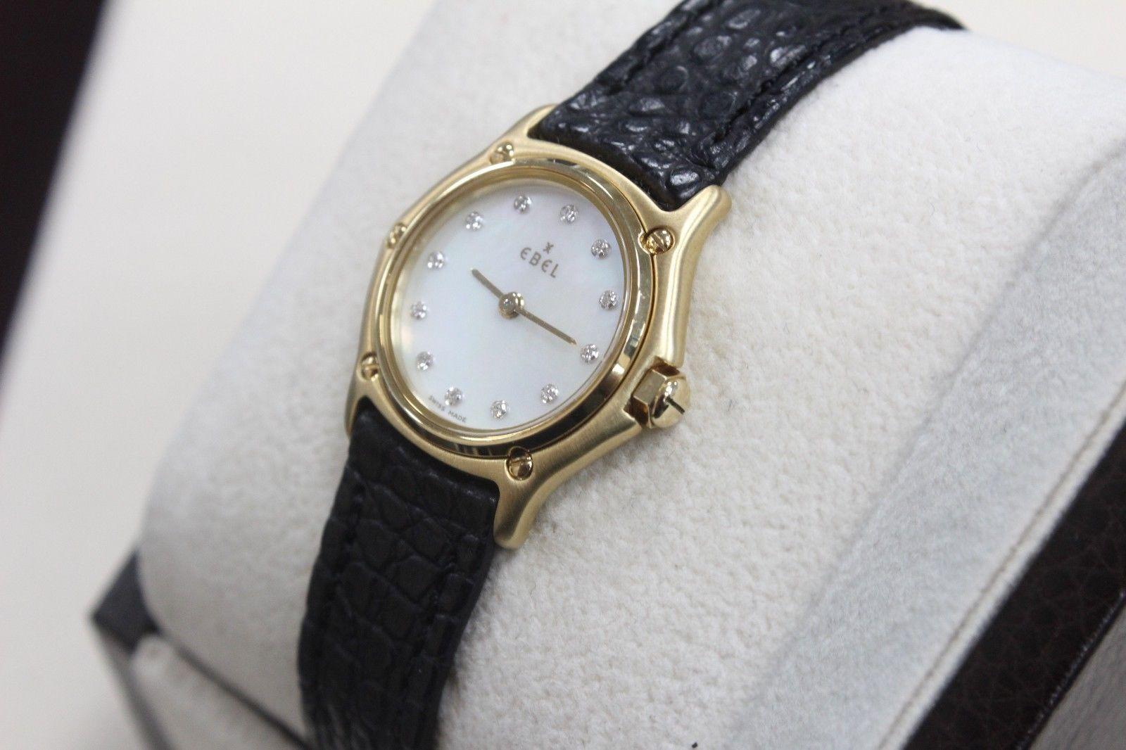 Model: Ebel Classic Wave
Style Number: 8157111 
Case: 18K Yellow Gold 
Band: Leather 
Bezel: 18K Yellow Gold 
Dial: MOP Diamond Dial 
Face: Sapphire Crystal 
Case Size: 25mm 
Includes: 
-Ebel Watch Box & Papers 
-Certified Appraisal 
-1 Year QD
