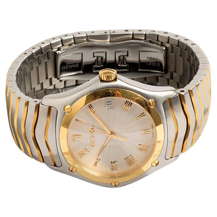 Unsere kultige Ebel Classic Wave verfügt über ein 40-mm-Gehäuse aus Edelstahl und 18-karätigem Gelbgold, ein Wellenarmband aus Edelstahl und ein weißes Zifferblatt mit römischen Ziffern. Präsentiert in hervorragendem Zustand mit nur leichten