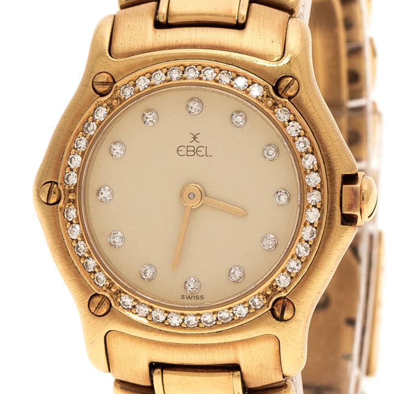 Powered by quartz movement, this Ebel wristwatch features an 18k yellow gold body and a rounded dial. The cream dial of this watch features a diamond-studded markers and gold-tone hands. It comes with a diamond-embedded bezel and surrounded by screw