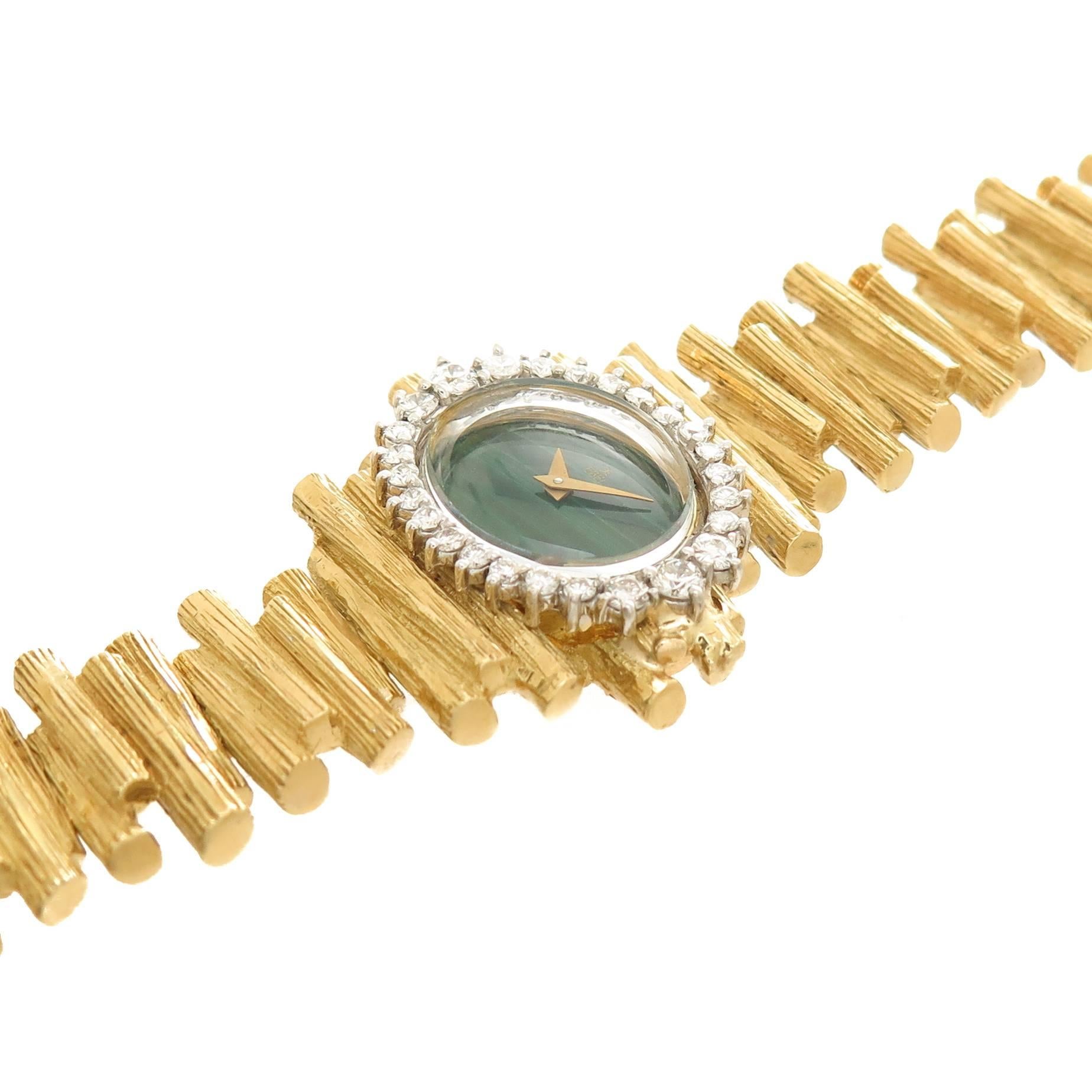 Circa 1960s Ebel 18K yellow Gold Ladies Wrist watch, measuring 6 3/4 inches in length and 5/8 inch wide with a textured finish. The White Gold Bezel is set with Round Brilliant cut Diamonds totaling 1 carat and grading as G in Color and VS in
