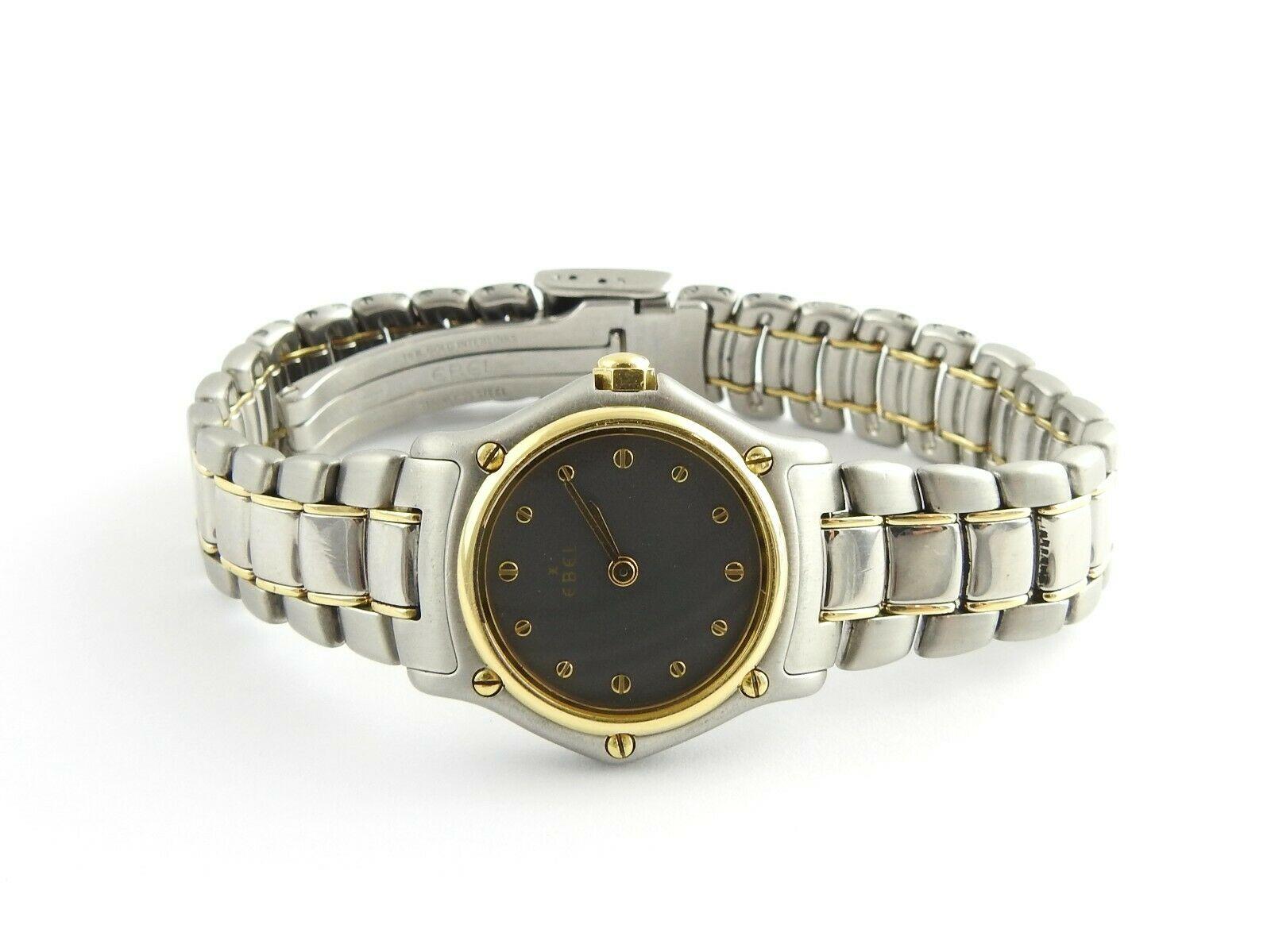 Ebel Mini Ladies Watch

Model: 18110895

Serial: 1057901

This watch is set in stainless steel with 18K yellow gold bezel and bars on band

Quartz movement

Case is approx. 20mm

Gray dial, gold screw markers

Fits up to 6.5