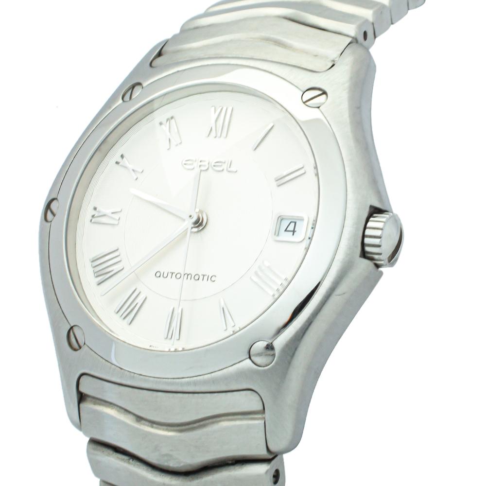 Classic and elegant, this Classic Wave wristwatch from Ebel is designed to complement your fashion taste with utmost subtlety. It has a stainless steel case with a screw-detailed bezel featuring a silver dial having Roman numeral hour markers, three