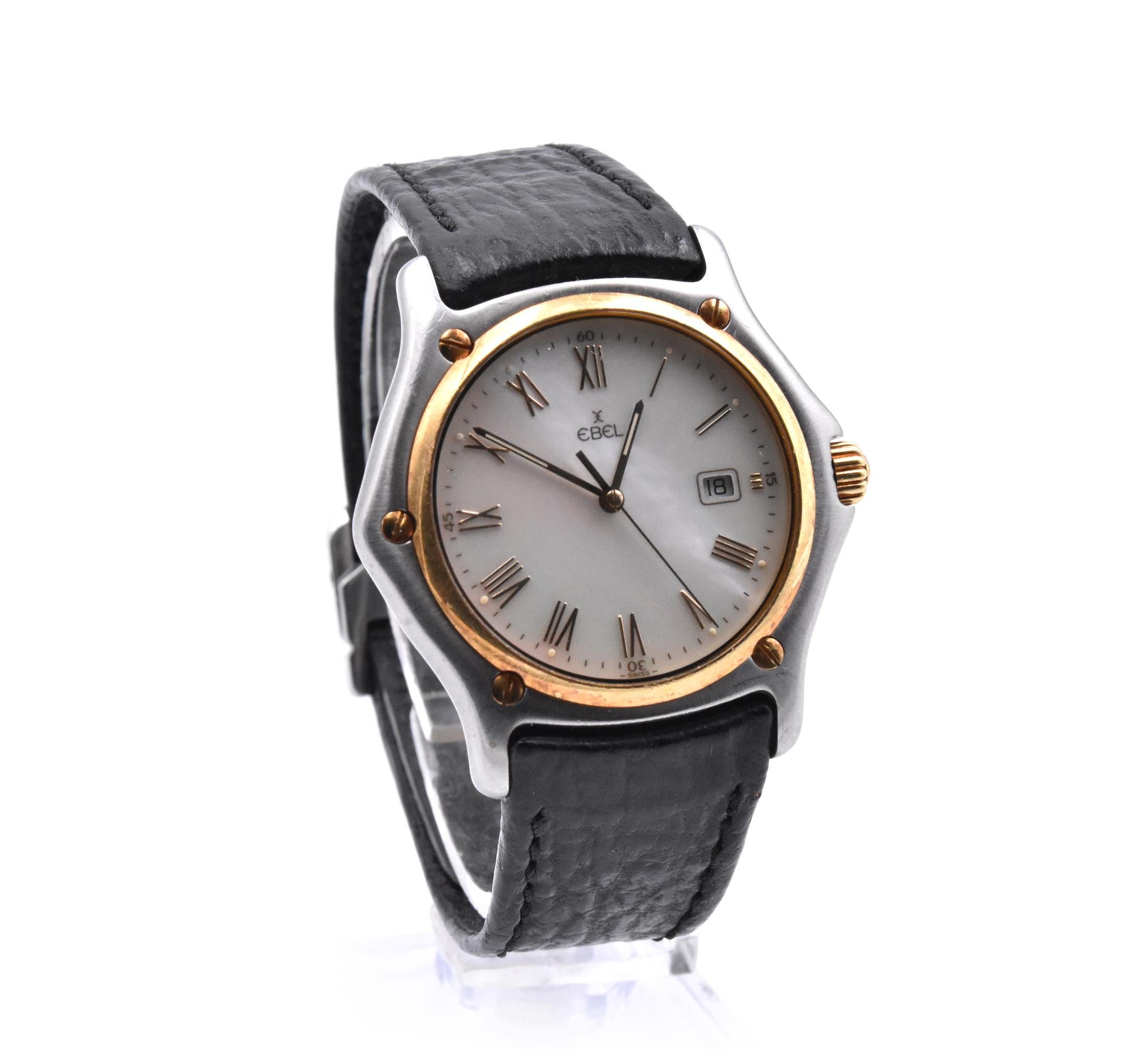 Movement: quartz
Function: hours, minutes, seconds, date
Case: 35mm stainless steel case, sapphire crystal, yellow gold smooth bezel, push/pull crown
Band: Ebel black leather strap
Dial: mother of pearl dial, date at 3 o’clock, gold hands, gold