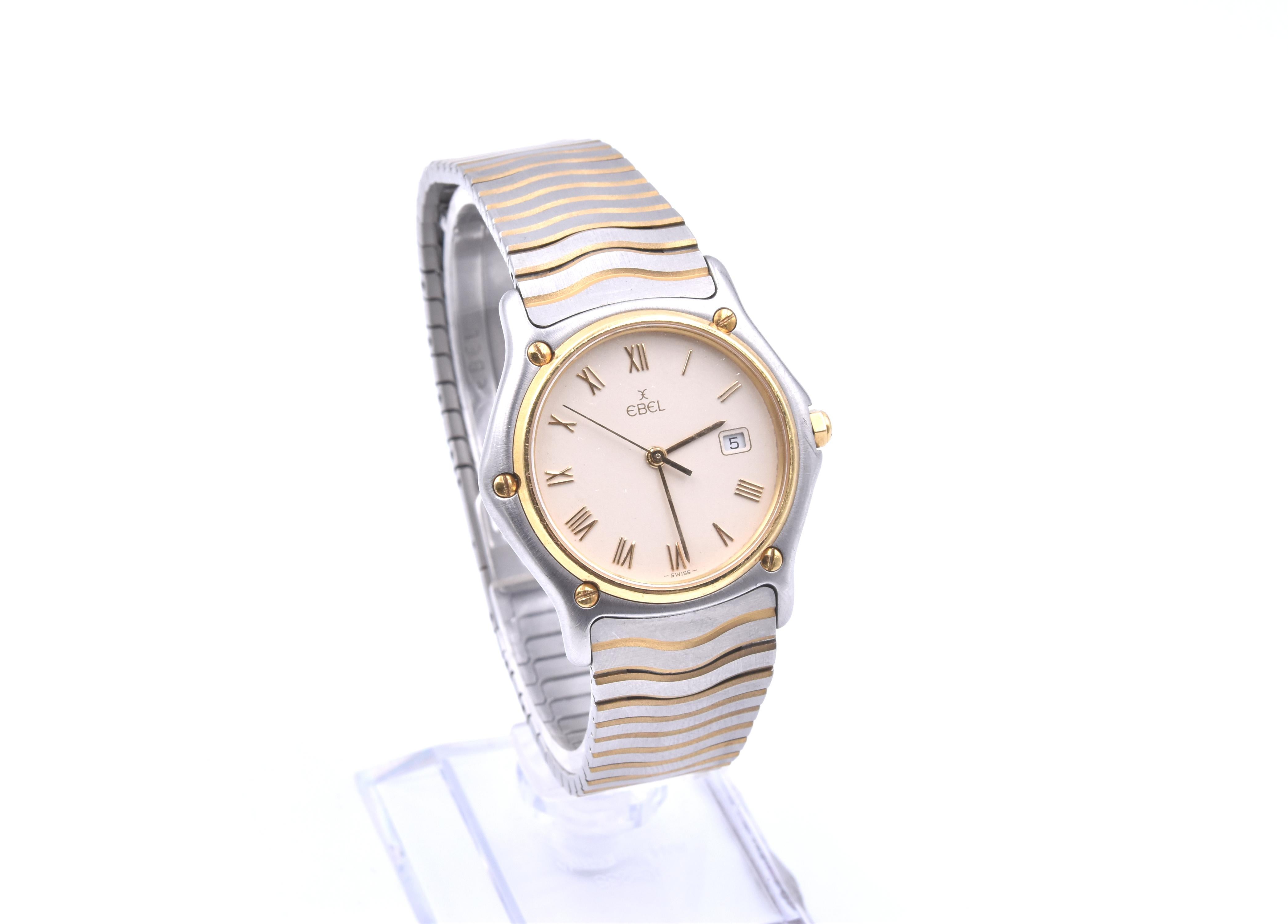 Movement: quartz
Function: hours, minutes, seconds, date
Case: 32mm stainless steel case, sapphire crystal, yellow gold smooth bezel, push/pull crown
Band: Ebel two tone wave bracelet, deployment clasp
Dial: cream dial, date at 3 o’clock, gold