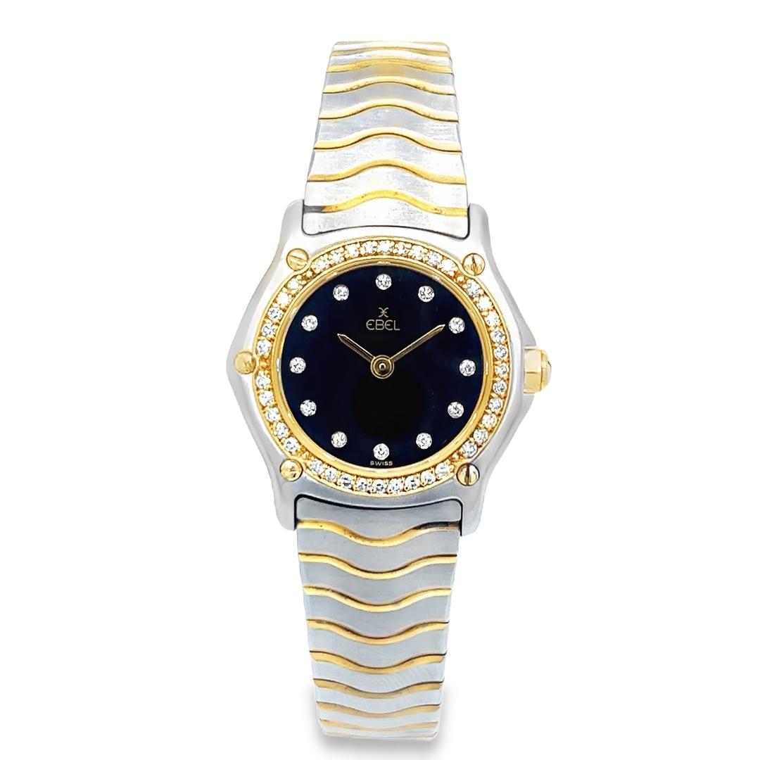 This pre-owned Ebel Wave Mini quartz watch showcases the brand’s signature blend of refined elegance and modern craftsmanship. Crafted in a timeless two-tone combination of stainless steel and 18K yellow gold, this 23mm timepiece features a